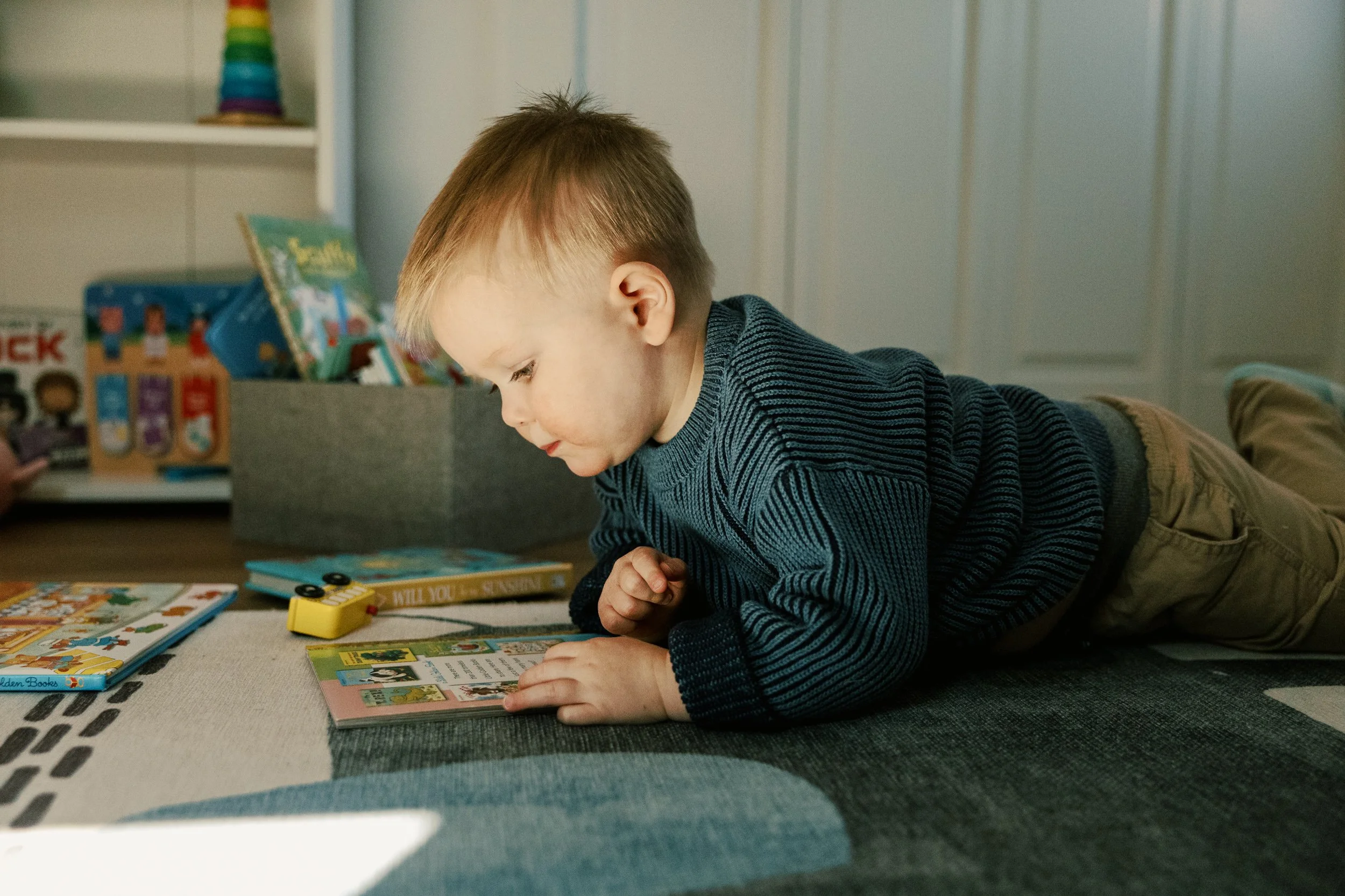 toddler takes a break with a book during family photos