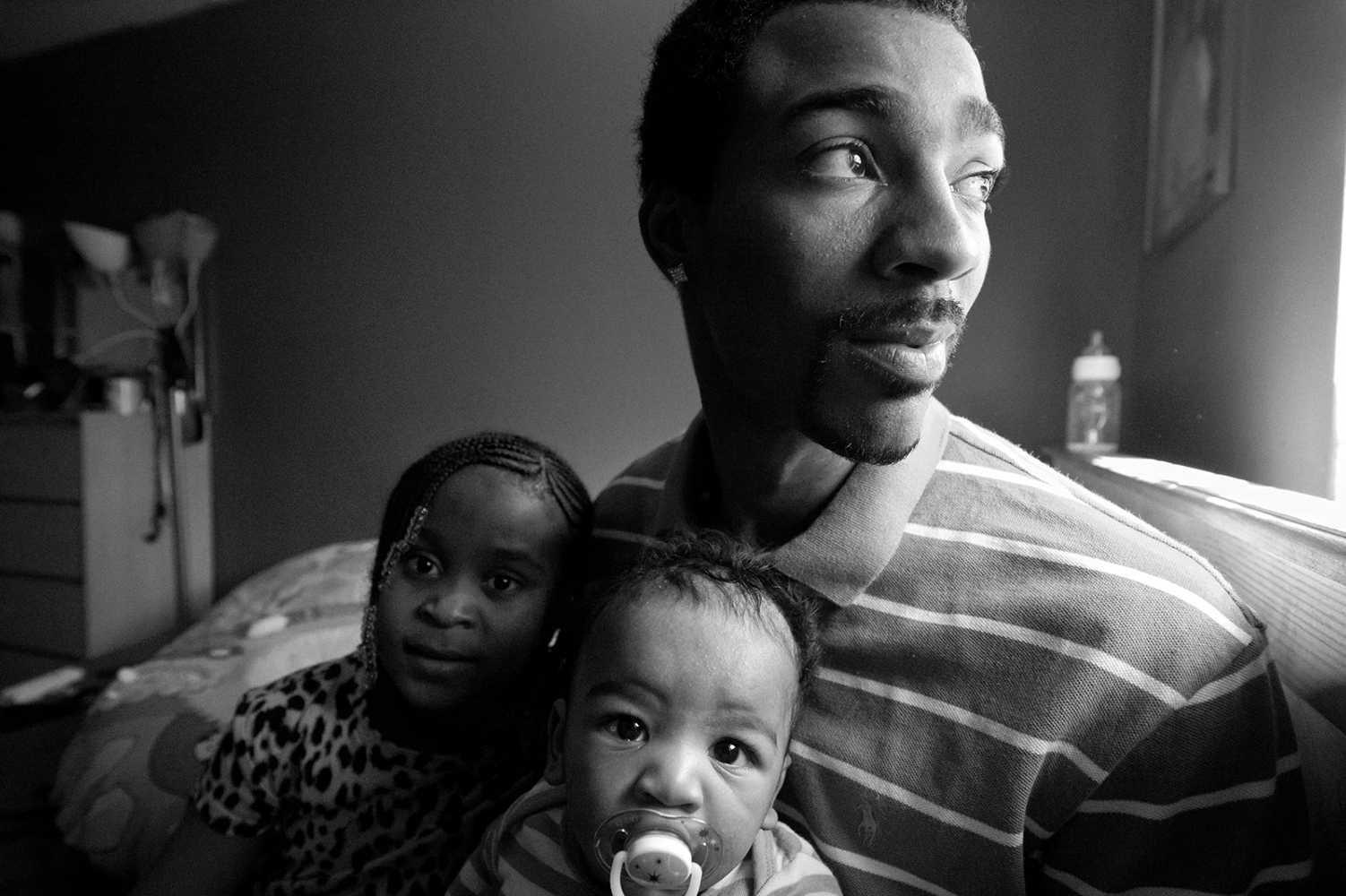  Zun Lee,  Guy Miller prepares for nap time with daughter Nijeyah and newborn Guy Jr.,  Bronx, NY, 2011 