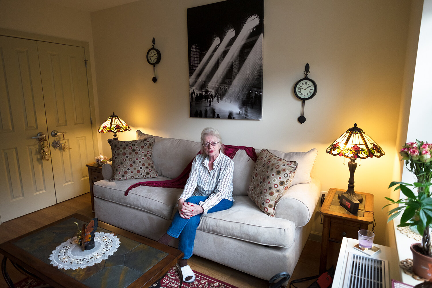  Rosalie, 70, on her couch bed in her studio apartment five months after her release. Image © Sara Bennett. 