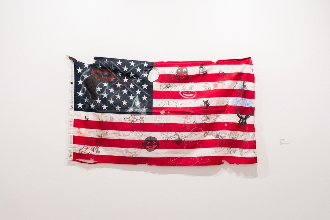 Andr&eacute; Ramos-Woodard
&ldquo;The Amerikkkan Flag&rdquo;, 2021
36&rdquo; x 60&rdquo;
Charcoal, graphite, pastel, marker, ink, ballpoint pen, cyanotype, dirt, spit, dog piss on burnt cotton flag

Andr&eacute; Ramos-Woodard&rsquo;s 2023 Critical Ma