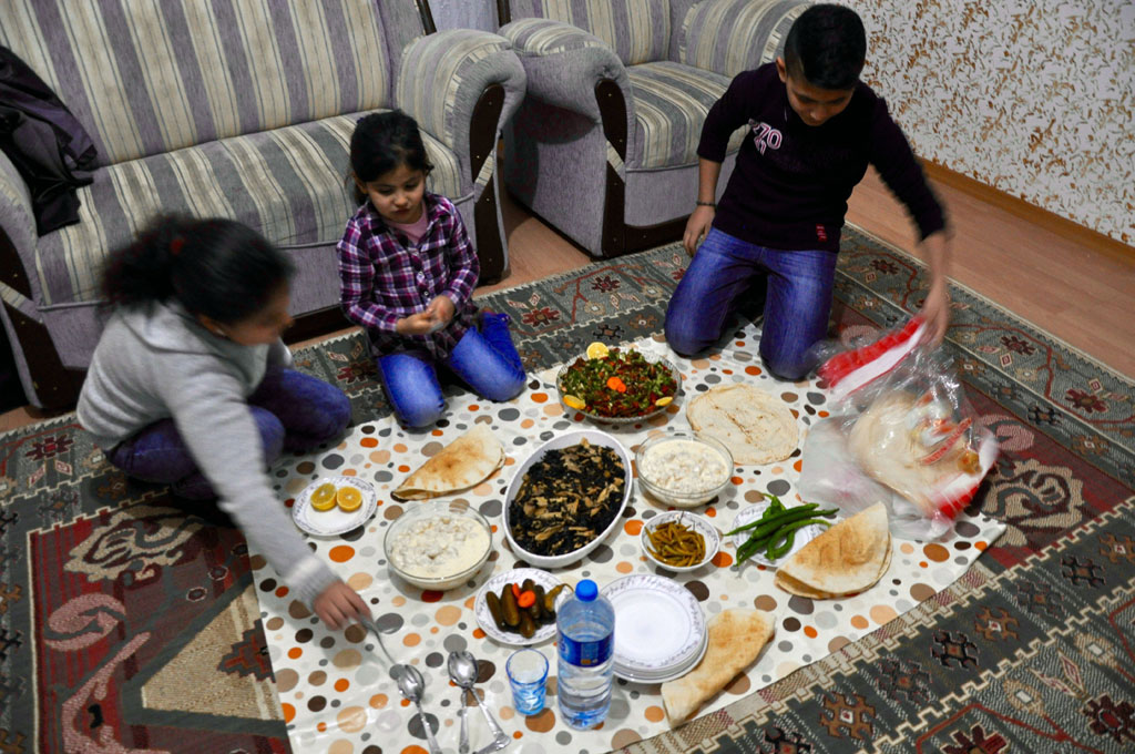 The Sheikho children Ruseel, Rivana and Rubi gather for dinner before they take the boat journey to Greece. (Photo by Lauren Bohn/GroundTruth)