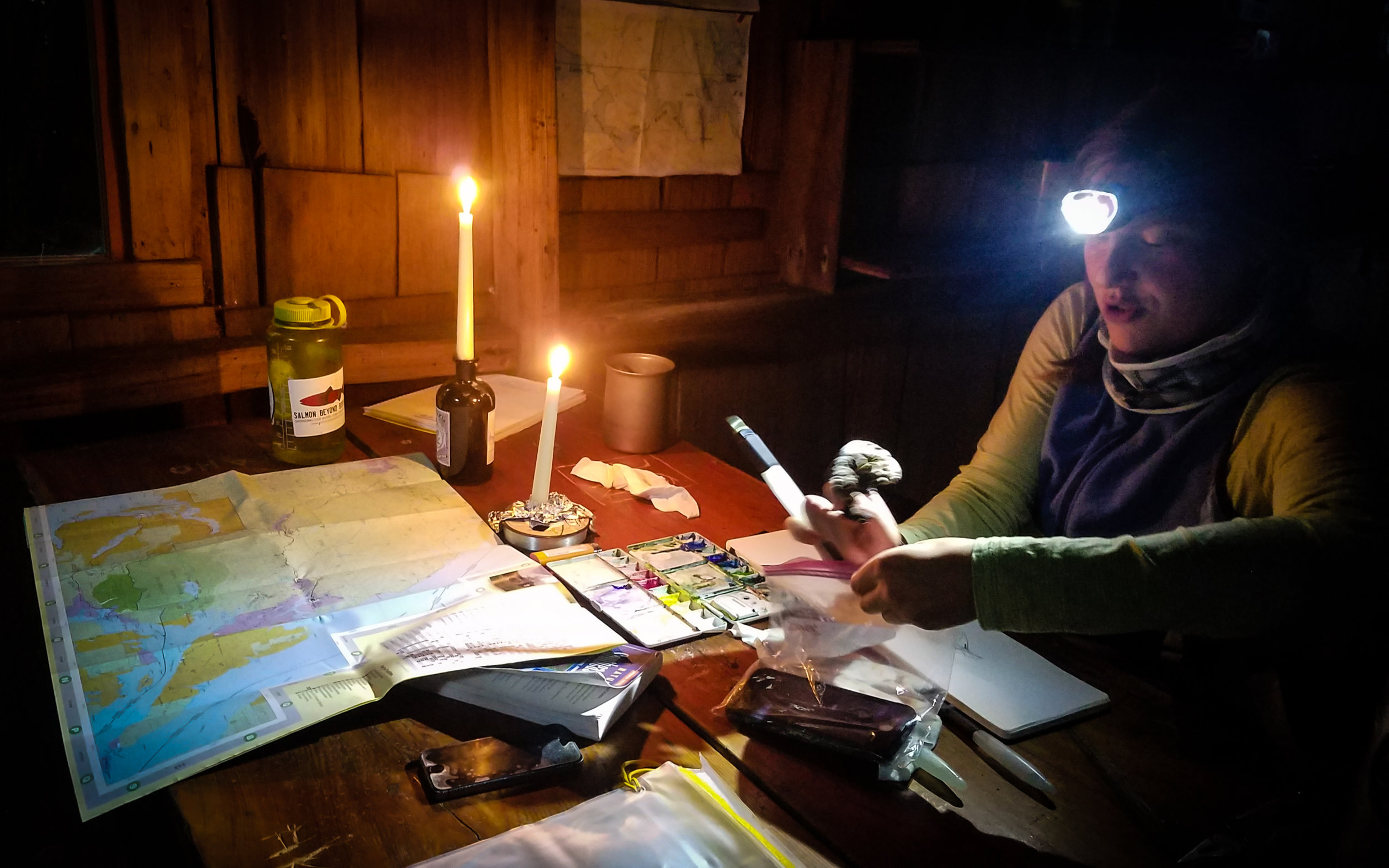 Mara illustrating by candle and headlamp