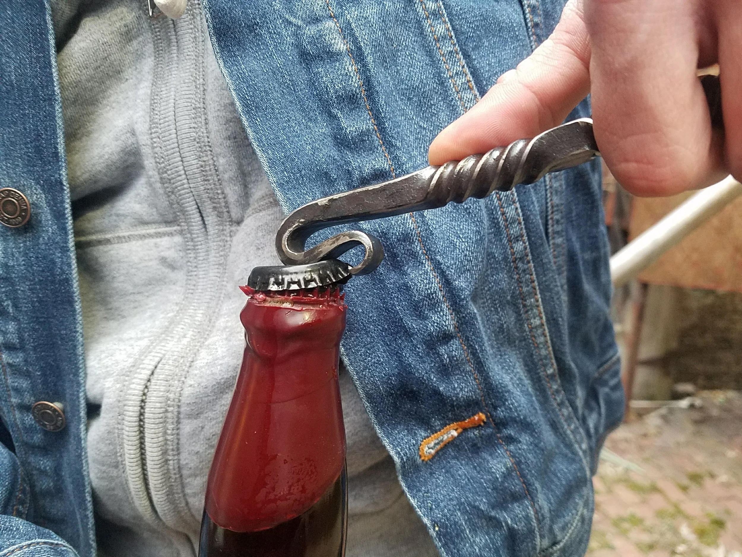 Hand forged, hand ground bottle opener complete with serrated edge for opening wax dipped bottles. Shown here effortlessly opening a fresh bottle.