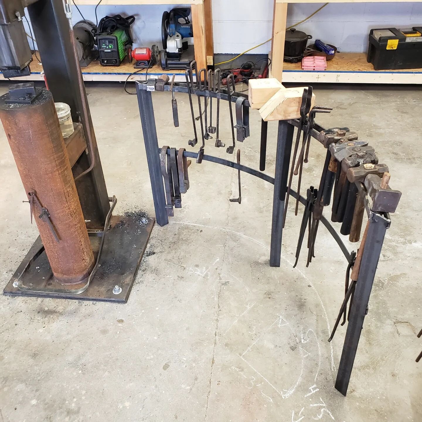 A few photos of the tool rack that came together this afternoon in shop. While not typical, it has three legs to help deal with the uneven floor. I think it is nice design that allows access to the hammer and also partitions out the space from the sh