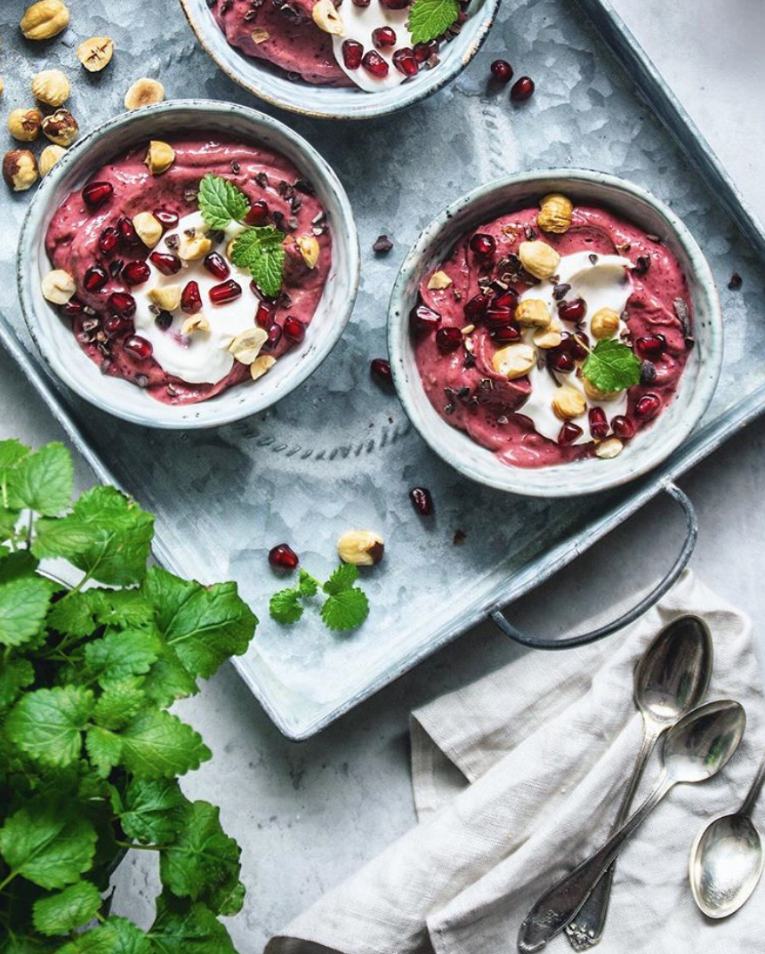 Soft raspberry ice cream with whipped coconut cream and hazelnuts