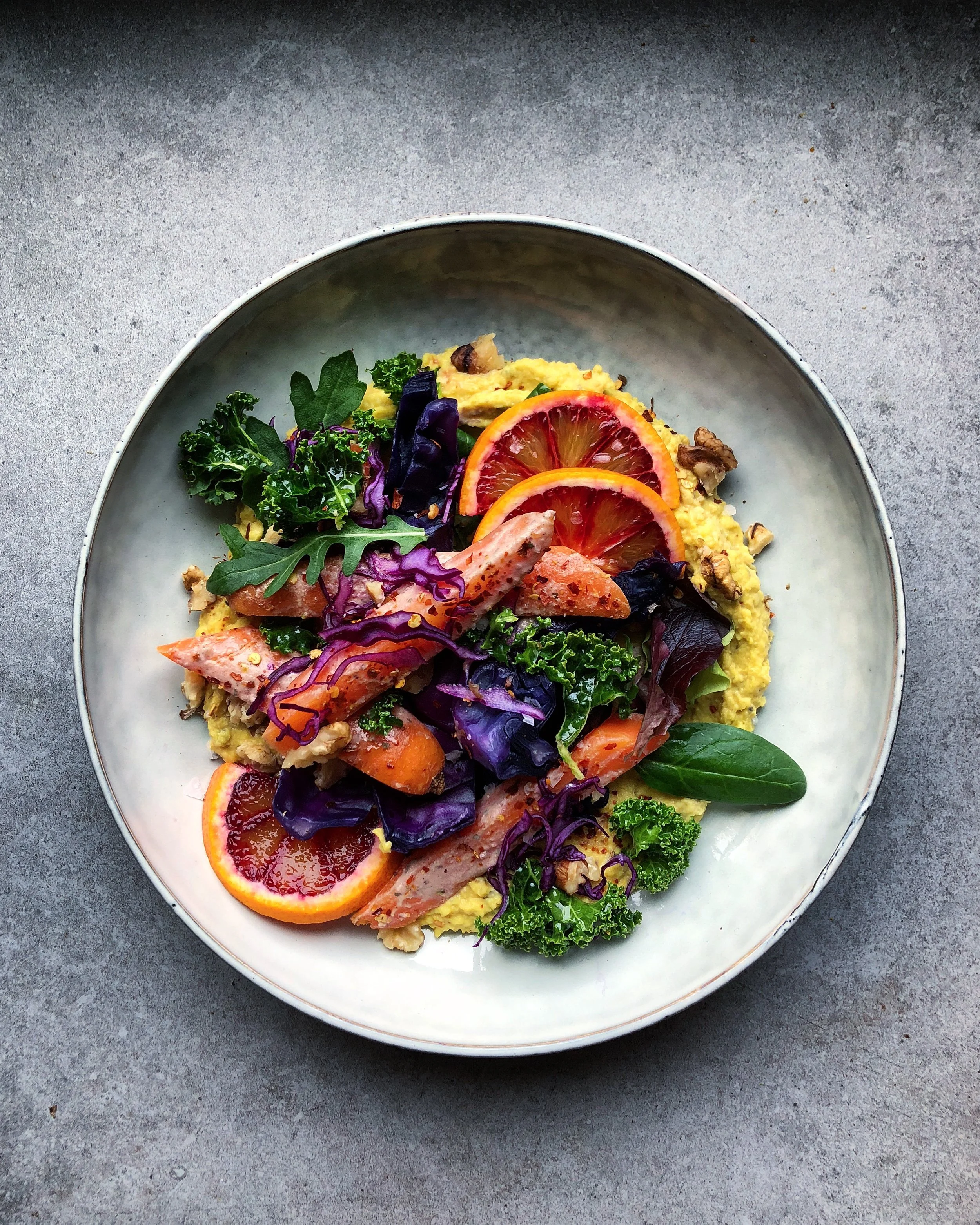 Golden hummus bowl with red cabbage, tahini dressed carrots and blood orange