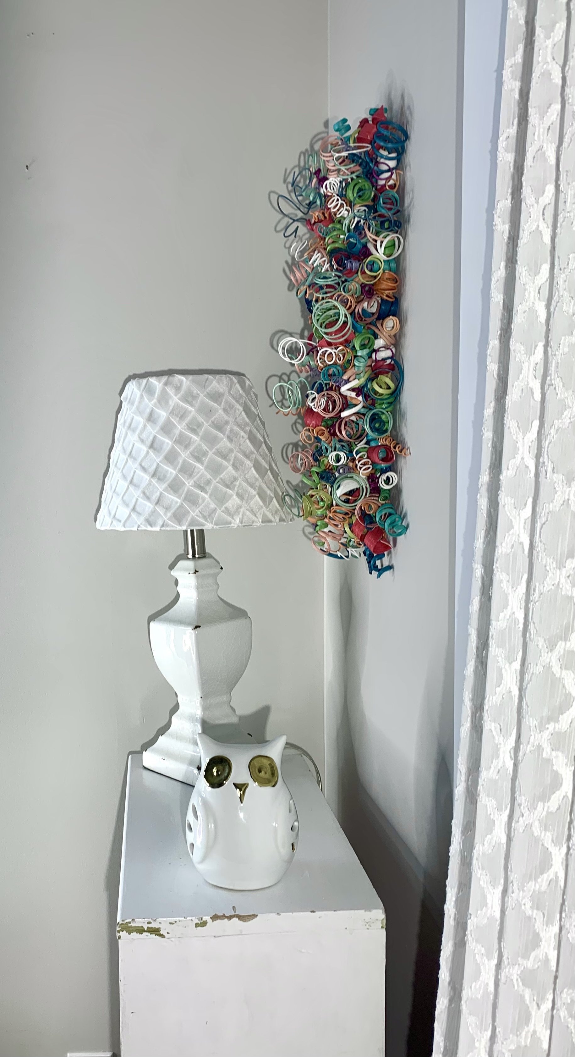 Twisted wooden reed wall art with vibrant hues