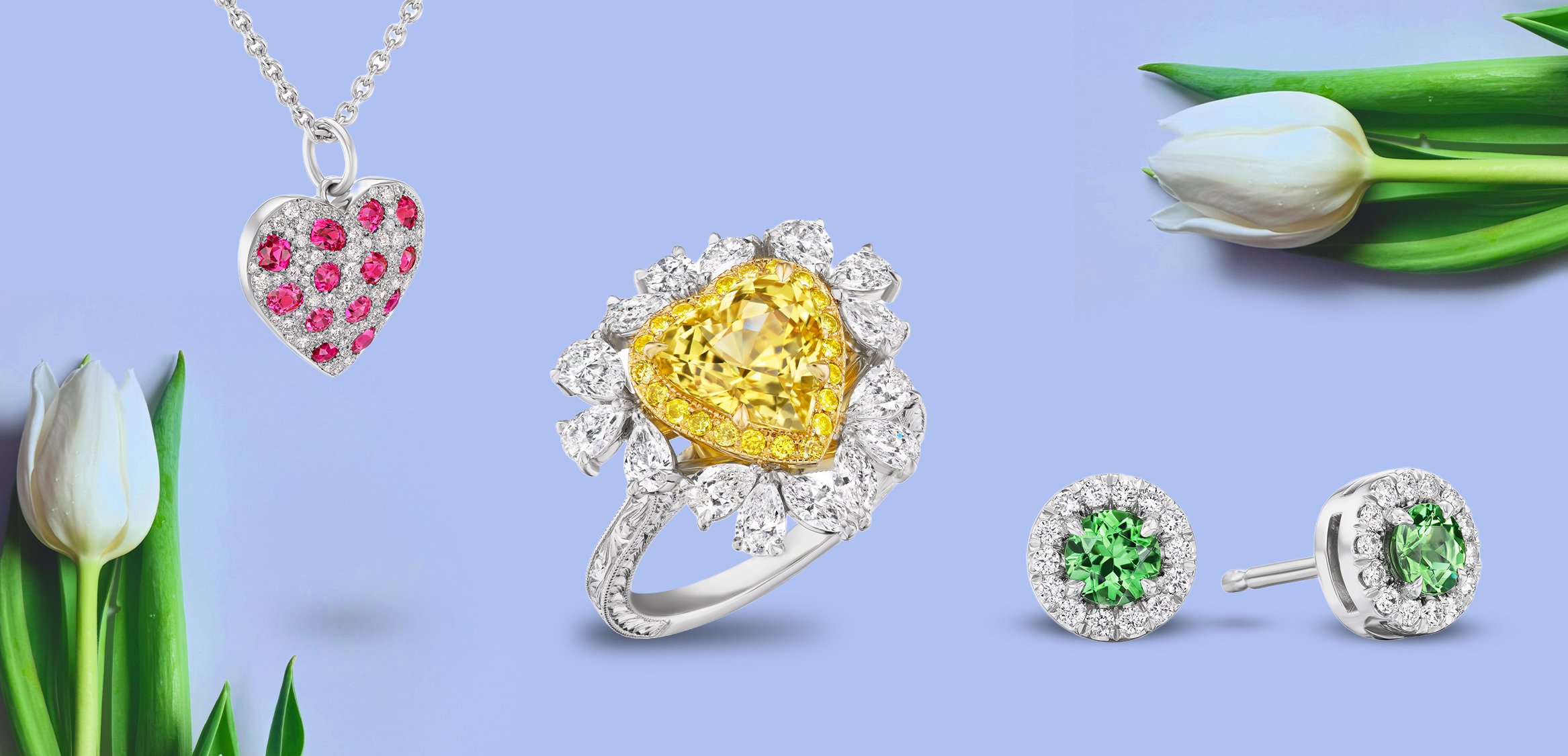 Jewelry with pink heart pendant, yellow sapphire ring, and green stud earrings on blue background.