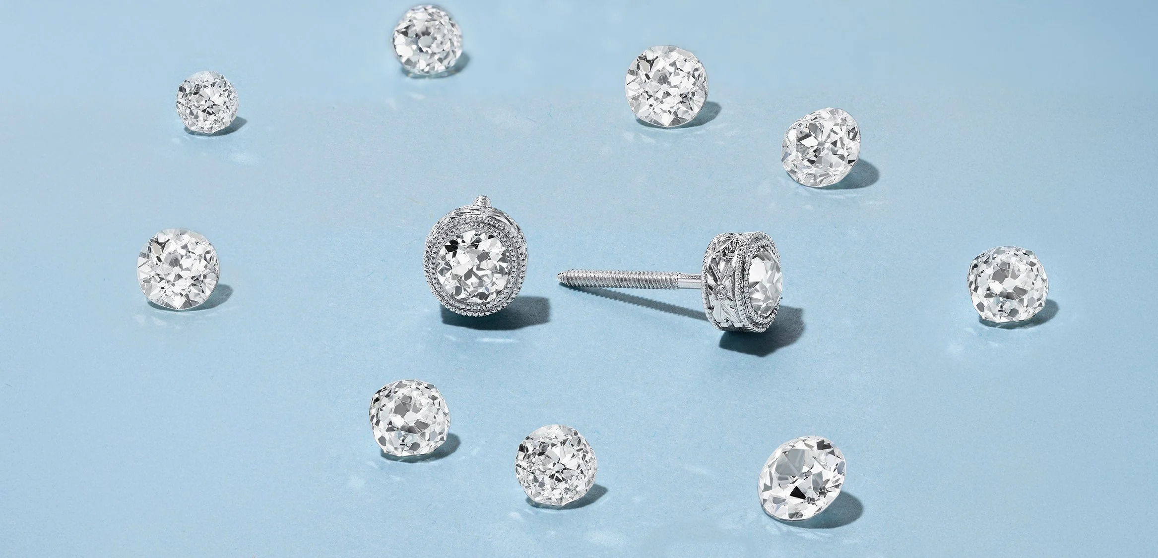 Diamond stud earrings on a light blue background