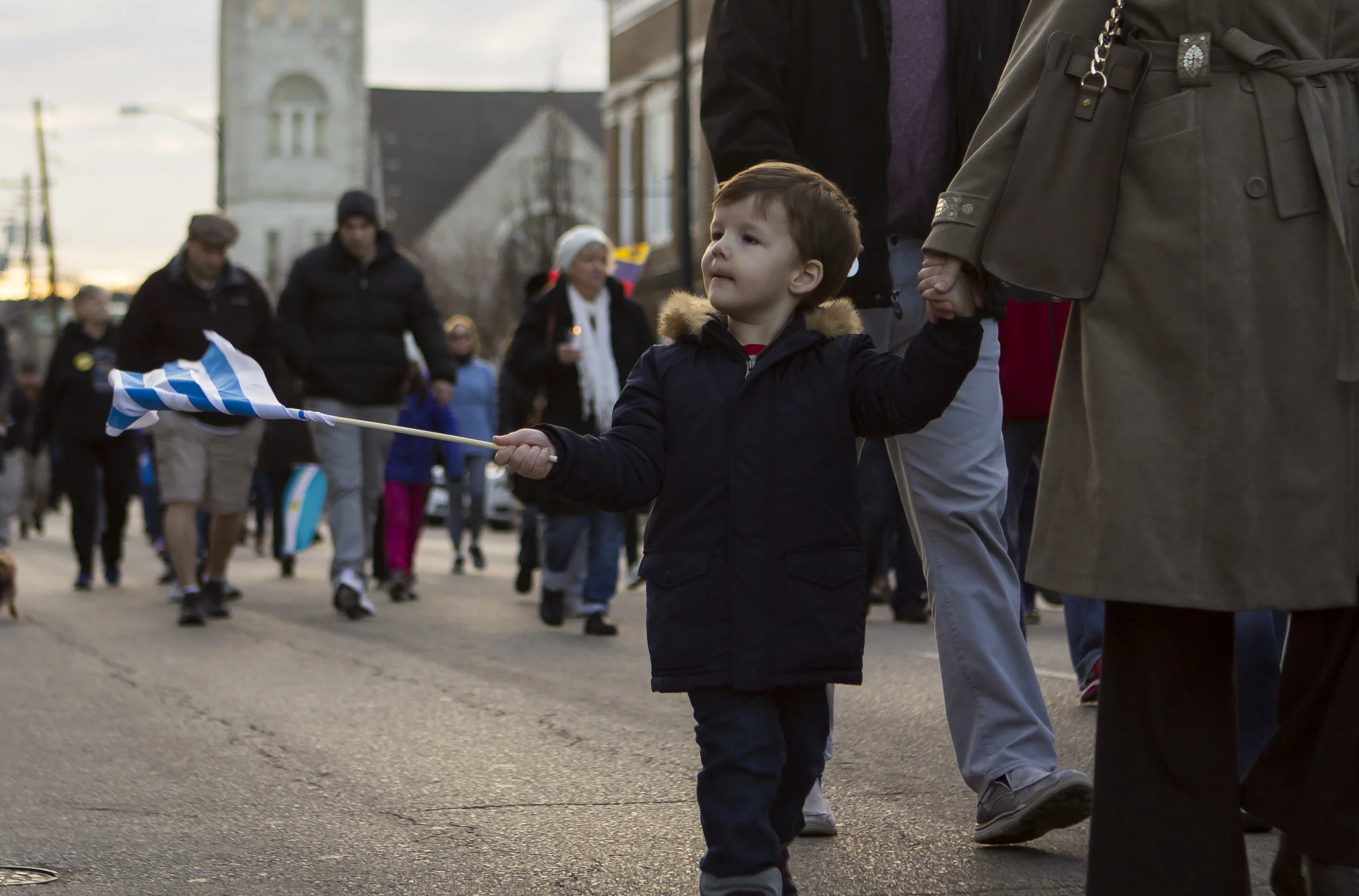 A boy swings a Uruguay flag at the Bowling Green Unity March held on Feb. 4th 2017. People were handing out flags from different countries during the march. Hundreds of people came out to support their fellow immigrant neighbors who had been affecte