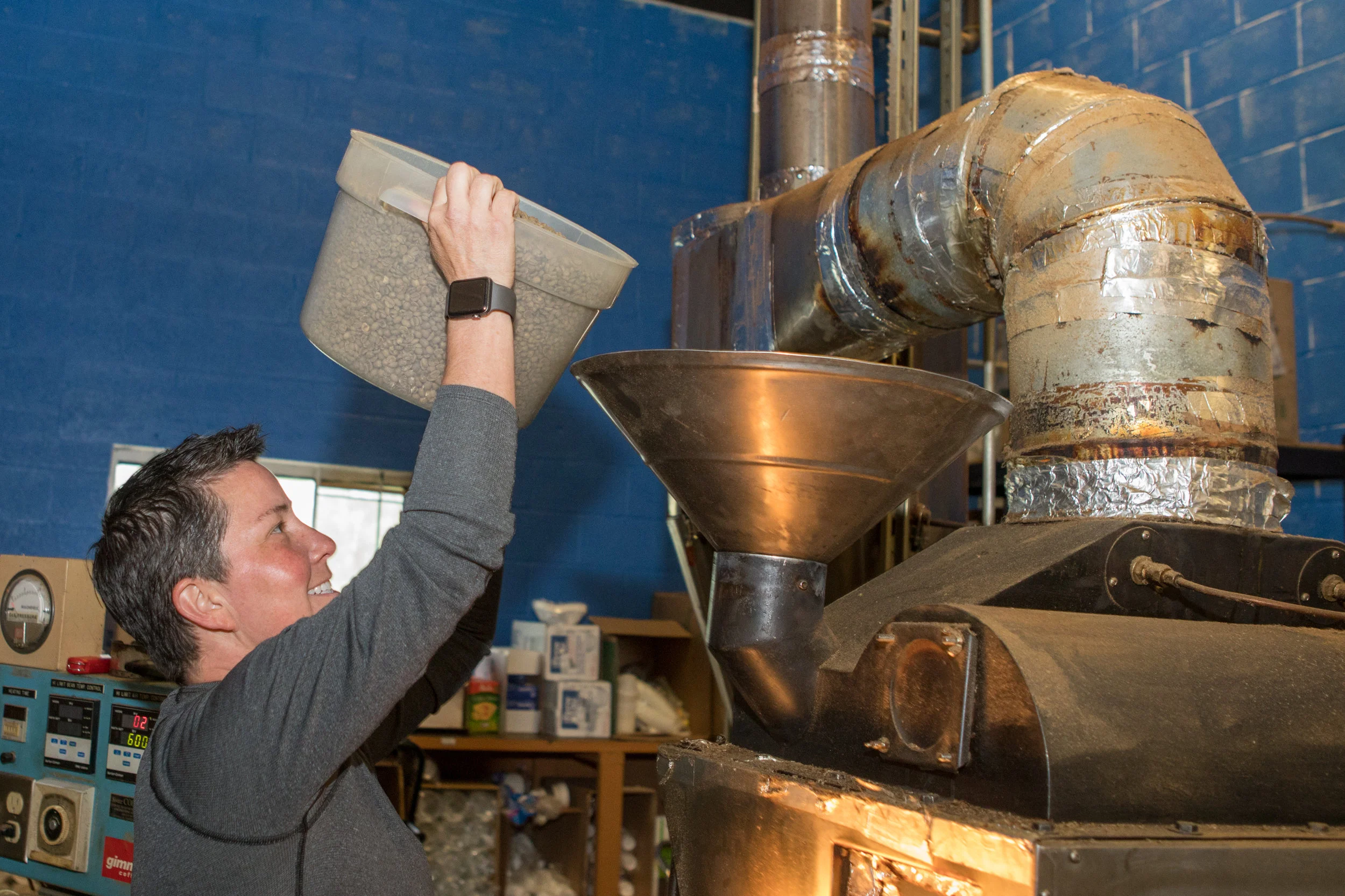 Serina Roy pours coffee beans into a roaster at Dublin Roasters Coffee. She started off roasting beans as a hobby when she worked as a Frederick Police Officer.