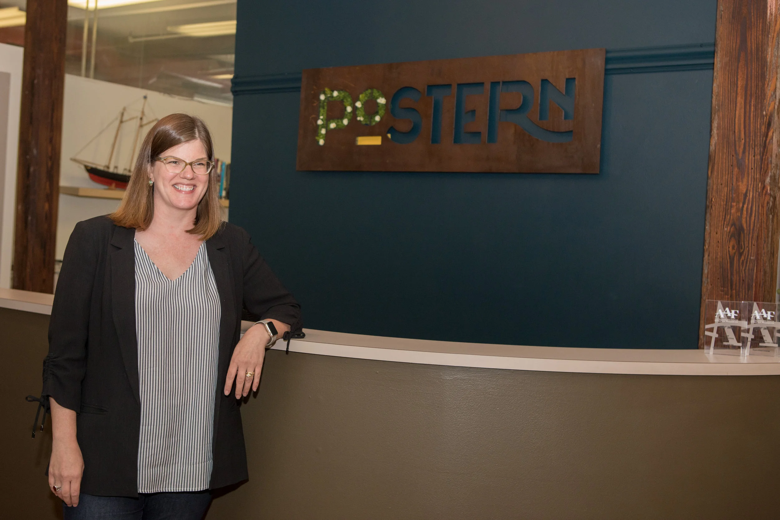 Emily Dorr poses next to the Postern Agency sign.