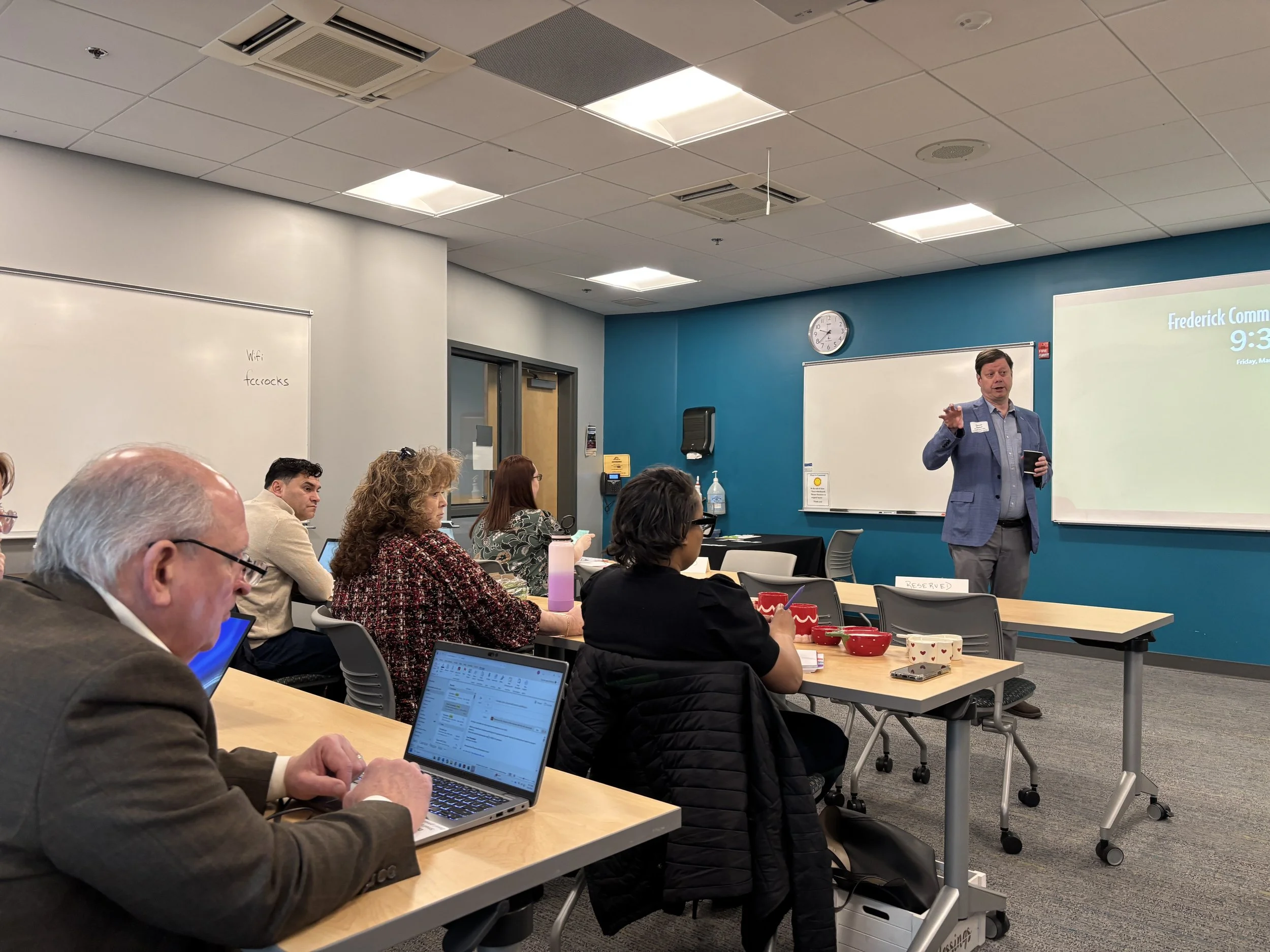 man teaching class in classroom in front of audience