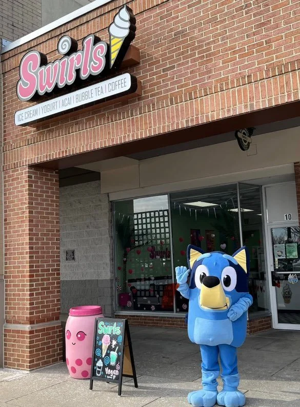 character in front of swirls building