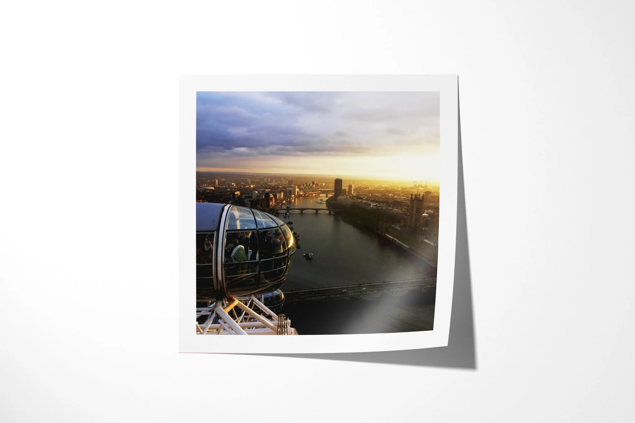 Fine art paper print of Eye In The Sky, showing London Eye capsules above the River Thames, Westminster Bridge and the Houses of Parliament at sunset.