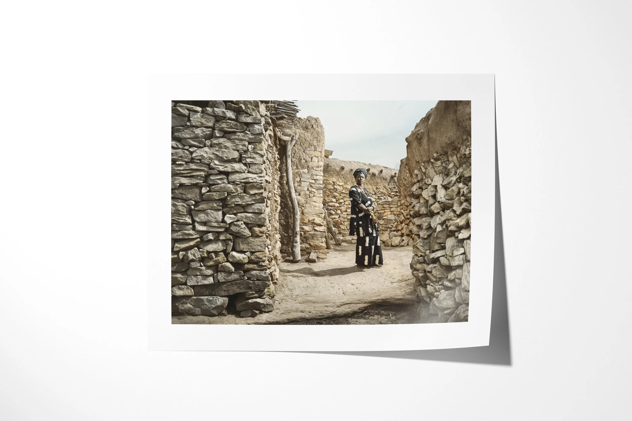 Fine art paper print of Yakoto, showing Yakoto standing in a narrow stone passage between the walls of a Dogon village.