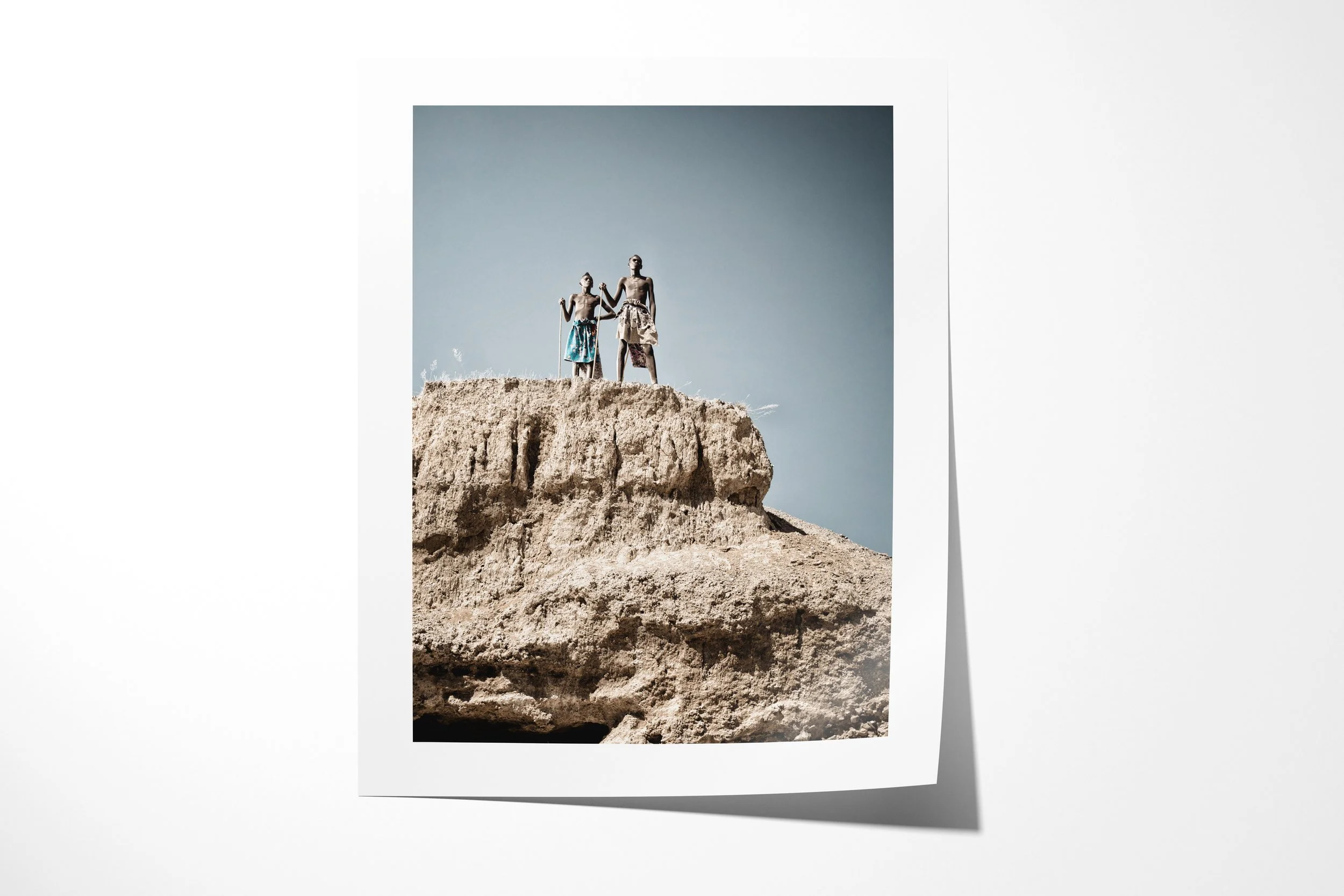 Fine art paper print of Mbangu (left) and Turimuno (right), showing Mbangu and Turimuno standing together on the edge of a high eroded rock formation.