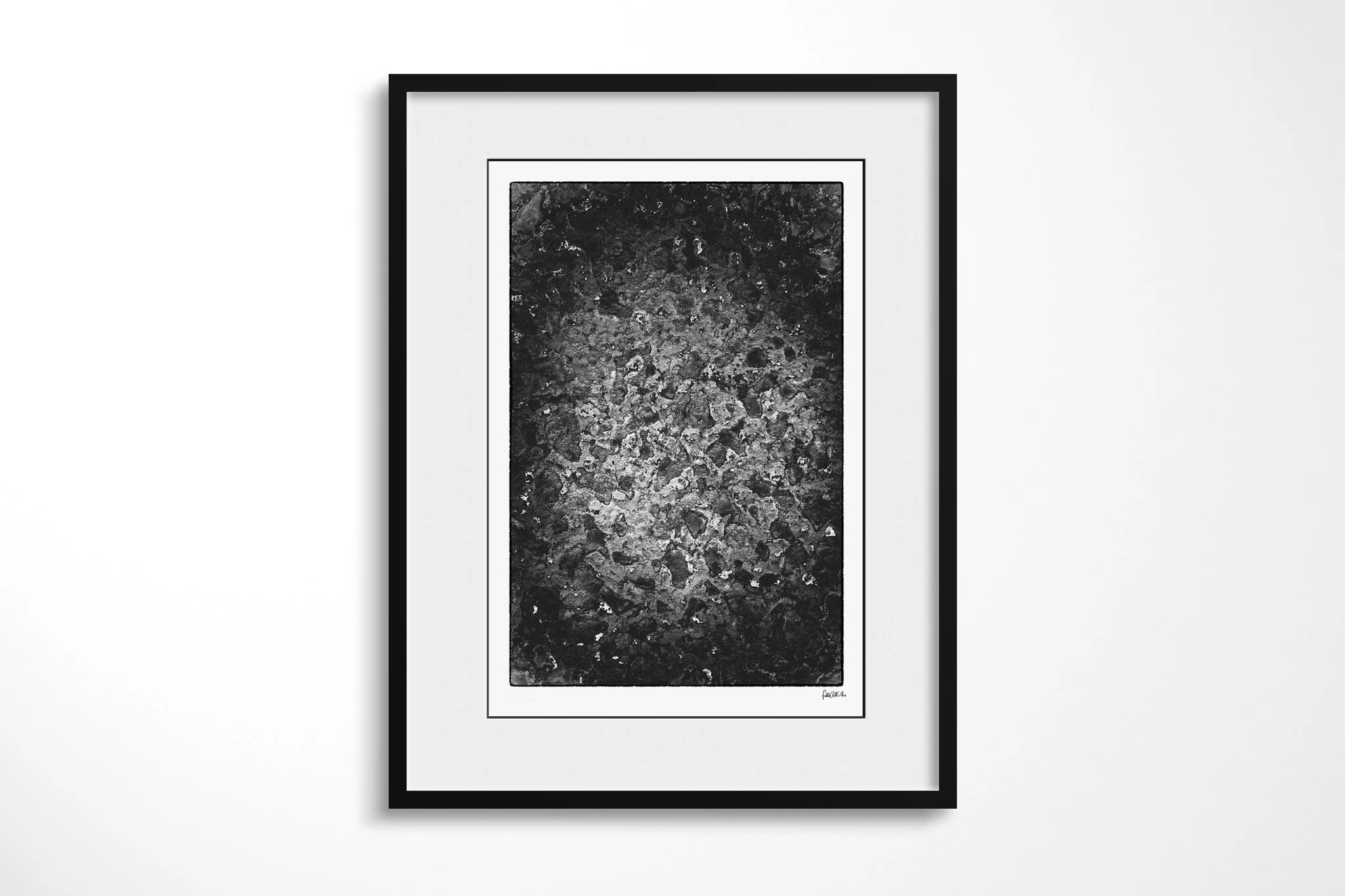 Framed presentation of Patina in a black frame with a wide white mount, showing a mottled monochrome surface with irregular pale encrusted patches, pits and dark weathered texture.