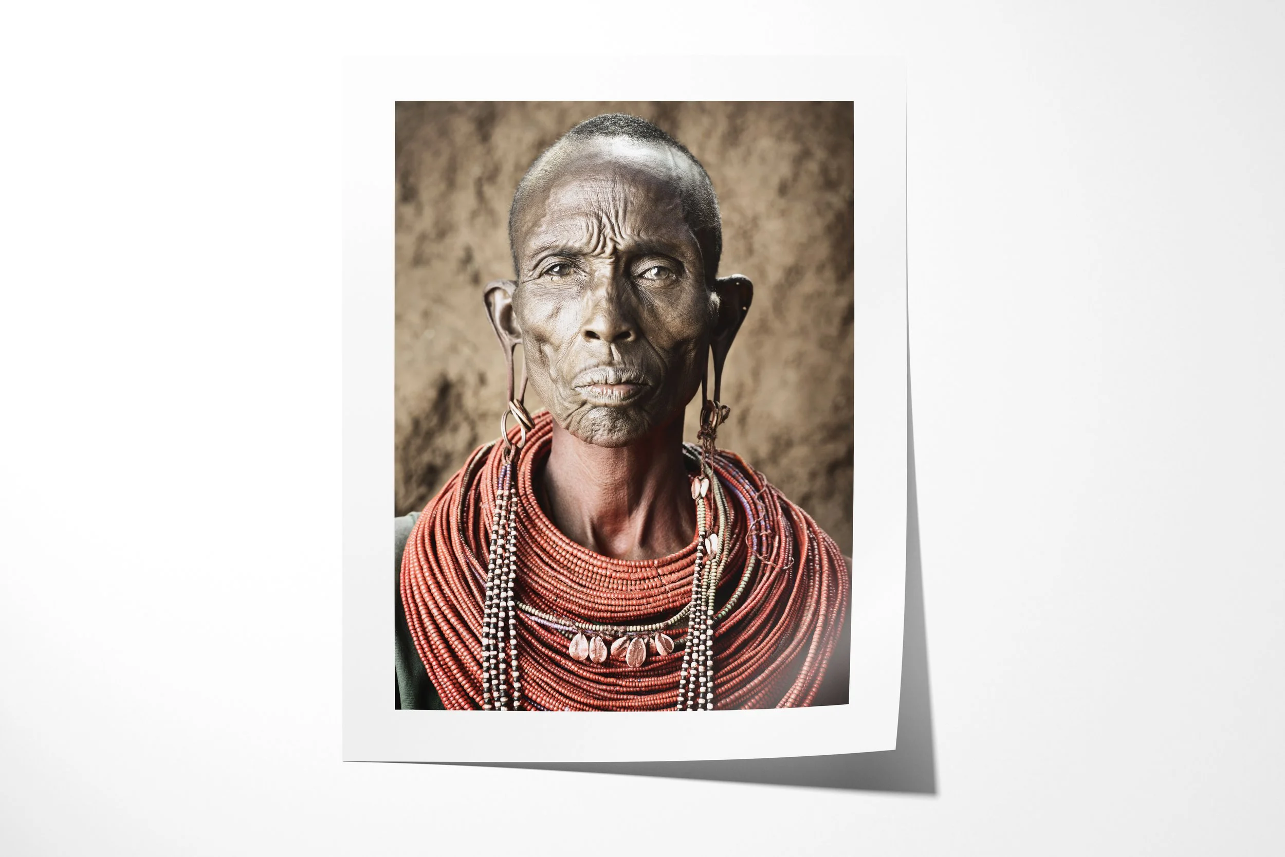 Fine art paper print of Nalary - “The Mother of Warriors”, showing a close portrait of a Samburu mother wearing ochre, layered beadwork and paired ear ornaments.