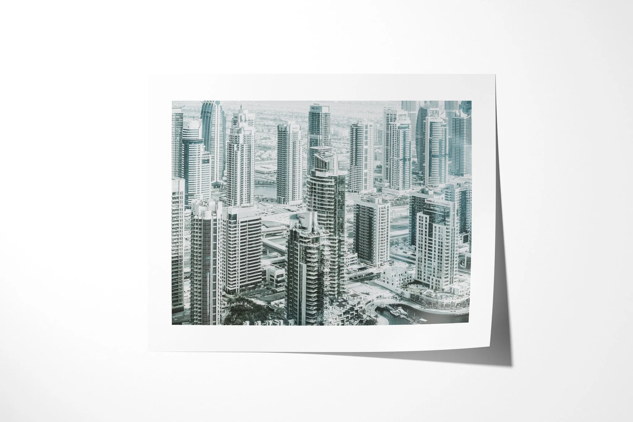 Fine art paper presentation of Concrete Jungle, depicting a dense modern cityscape of high-rise towers, balconies, roads and waterways seen from above in cool pale tones.
