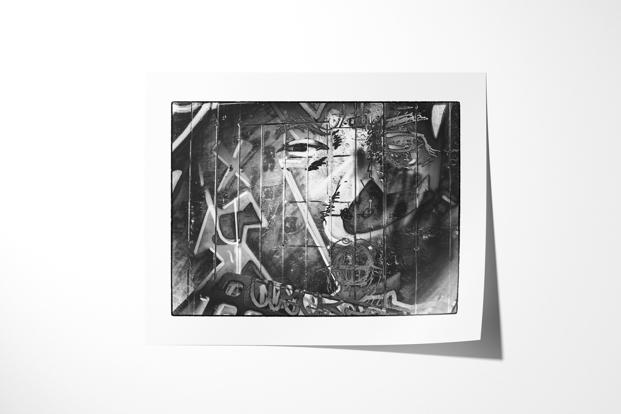 Impression II presented as an unframed fine art paper print, showing a stylised eye and face spanning a panelled monochrome surface with angular graffiti-like lines and symbols.