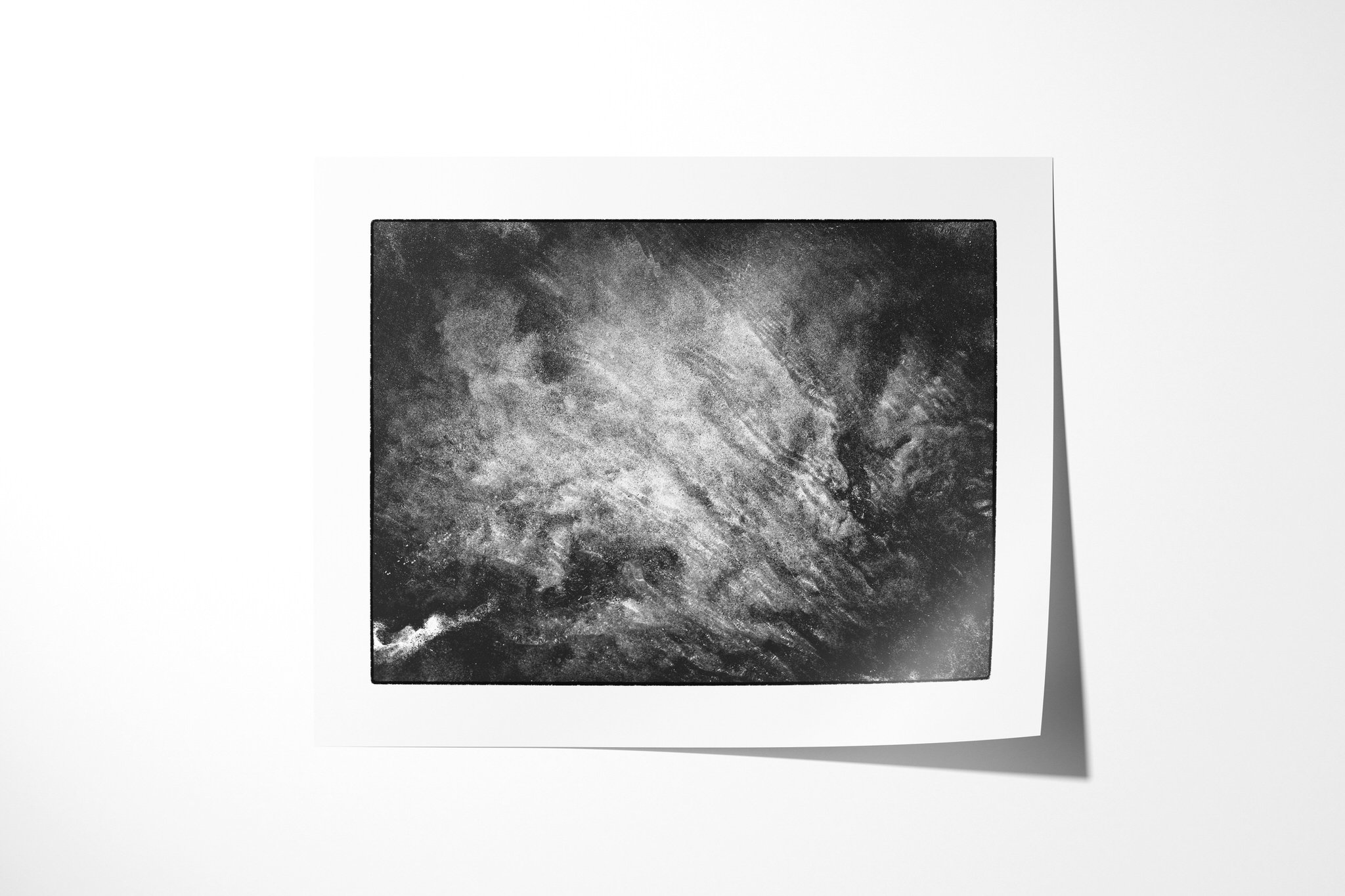 Manganese I presented as an unframed fine art paper print, showing a pale diagonal sweep of layered streaks across a dark, clouded granular field.