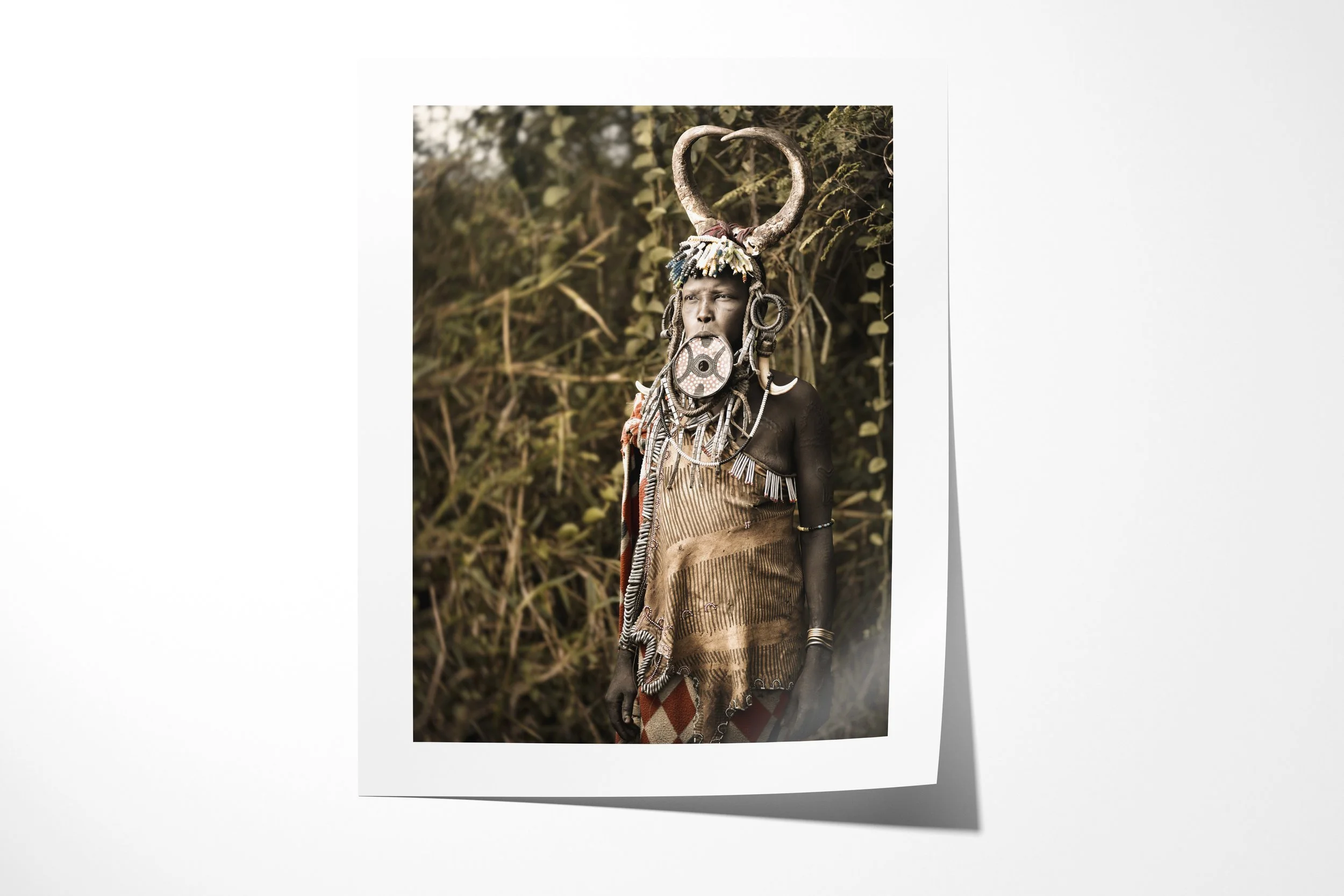 Fine art paper print of Madhawori, showing a Mursi woman wearing a painted lip plate, beadwork and a circular horn headdress.