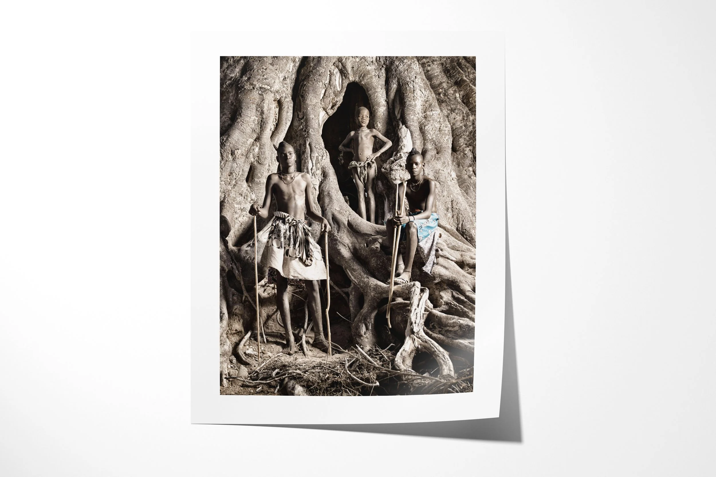 Fine art paper print of Turimuno (left), Kakoke (middle) and Mbangu (right), showing three Himba boys standing among the roots and hollows of a monumental fig tree.