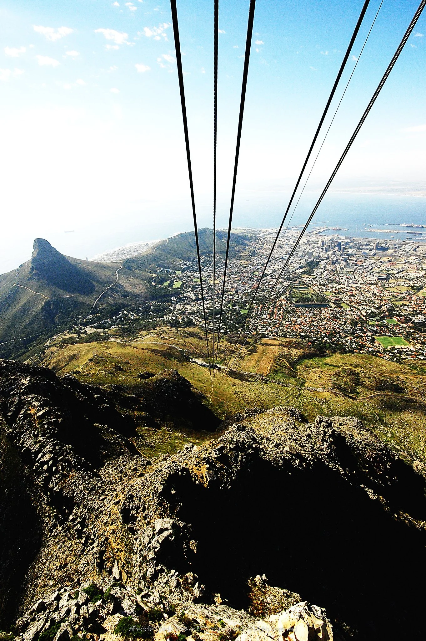 Cable lines descending above Lion's Head, Cape Town's city bowl, harbour and Atlantic coast.