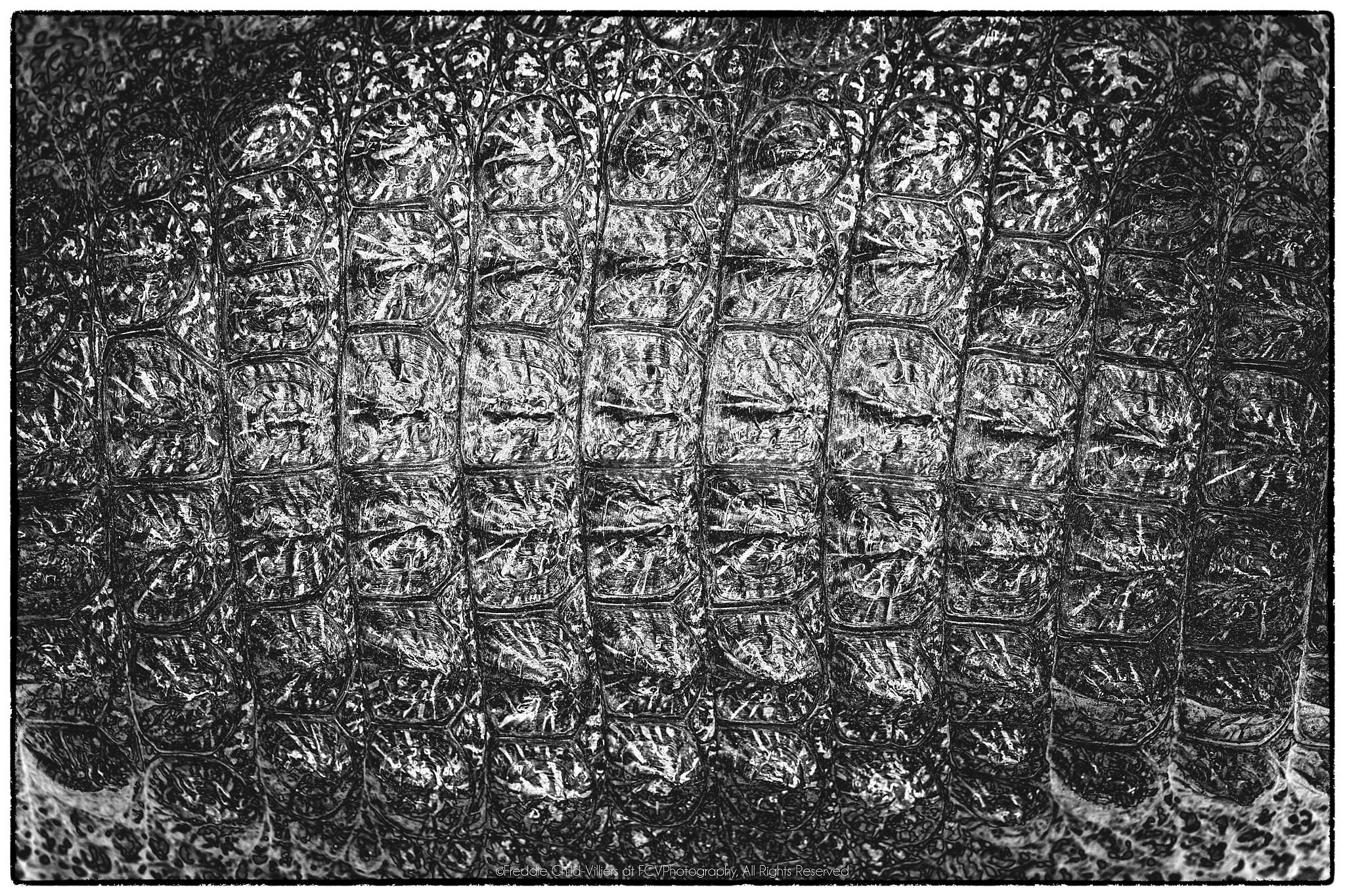 Grid of compressed translucent containers with crumpled, reflective surfaces.