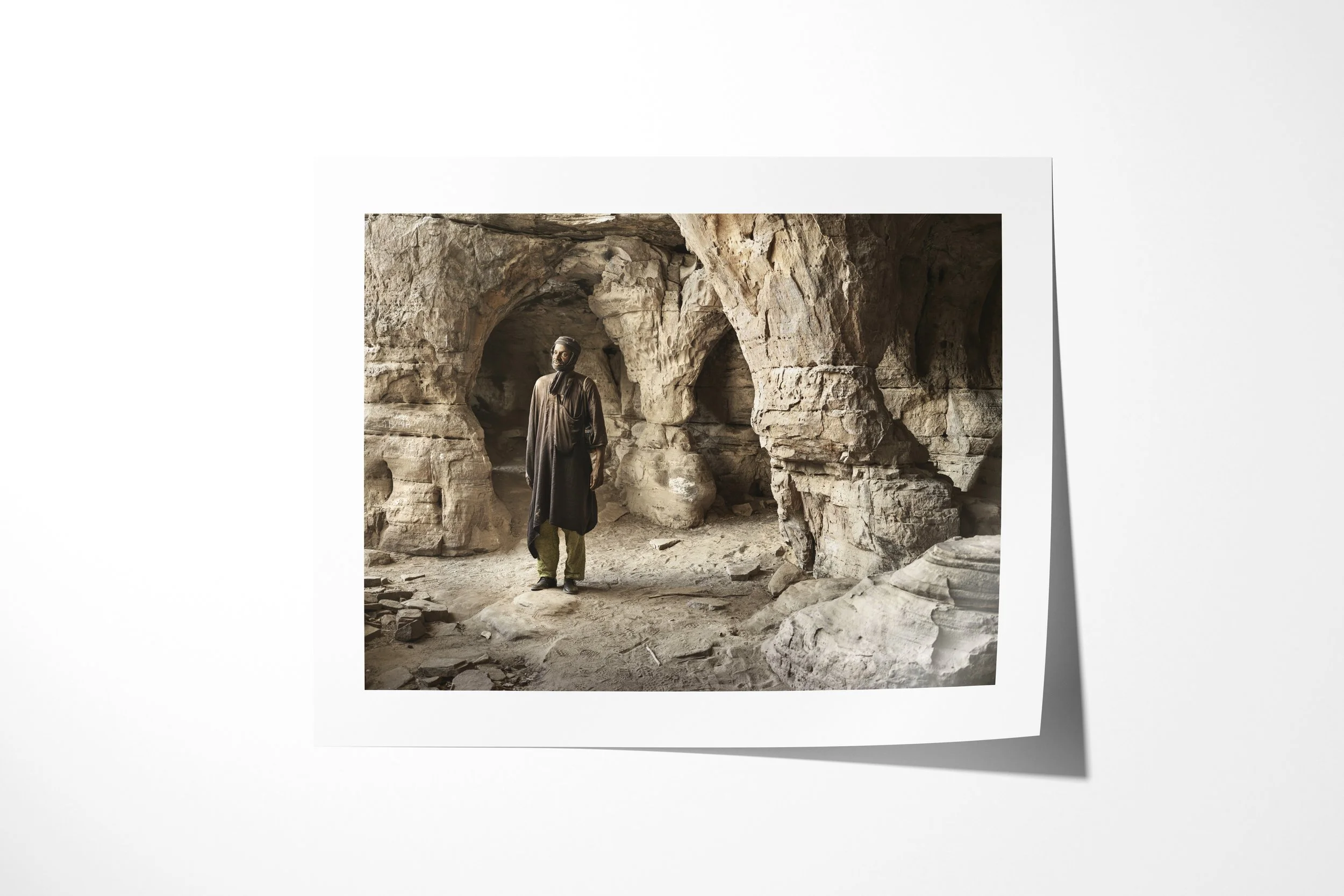 Fine art paper print of Alou, showing Alou standing within the carved arches and columns of a sandstone cave.