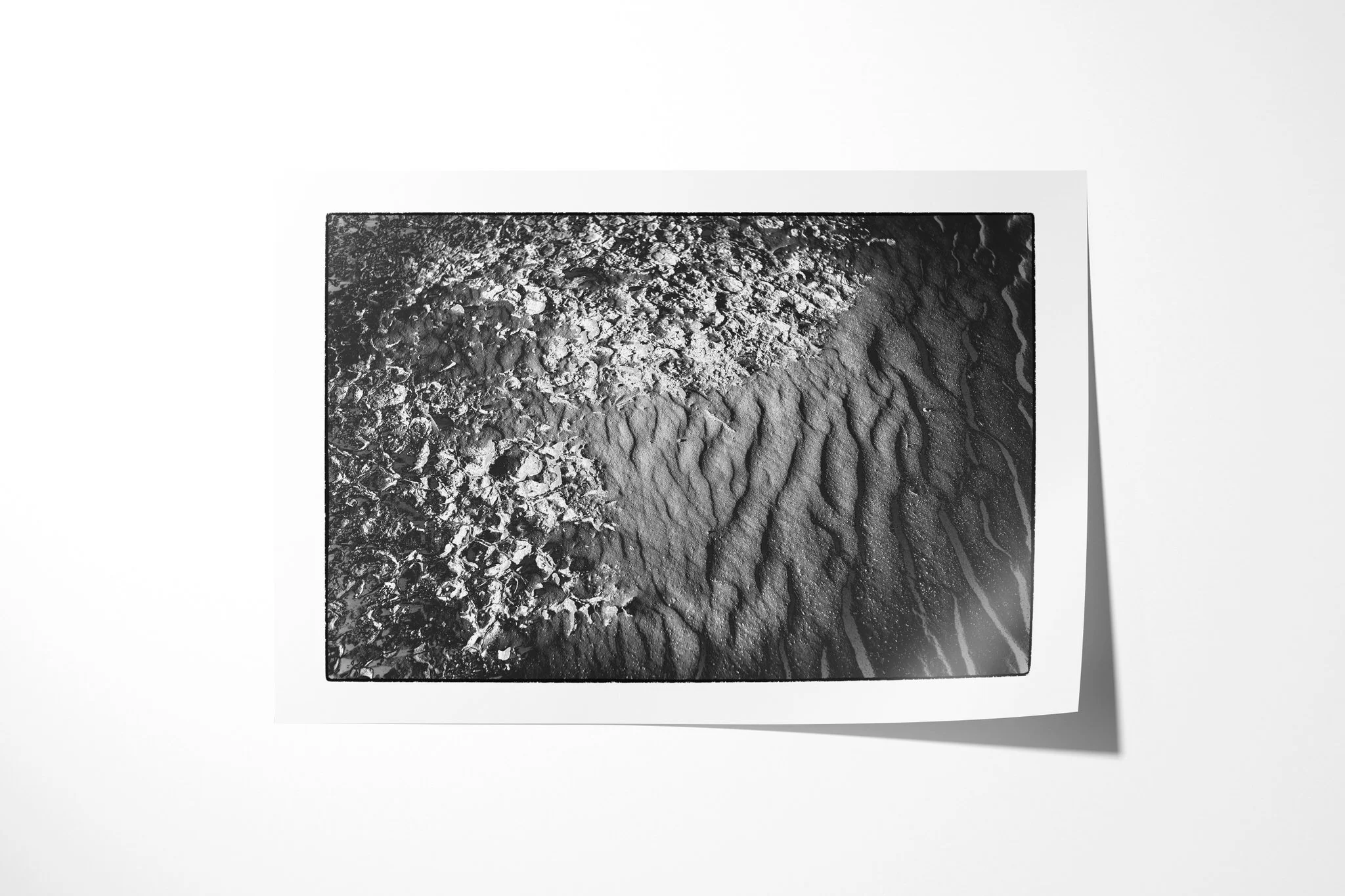 Unframed fine art paper print of Khamsin III, featuring broken granular crust meeting smoother rippled sand along an irregular curved boundary.
