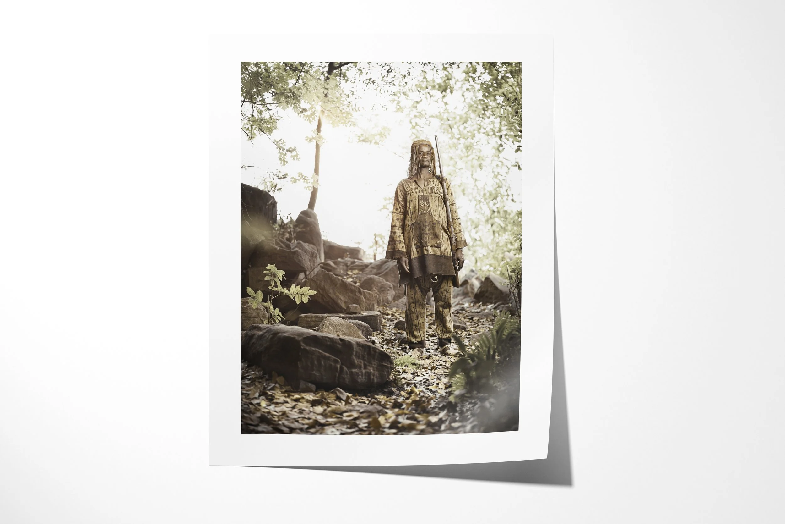 Fine art paper print of Bandjougou, showing Bandjougou standing among rocks and trees in a shaded green valley.