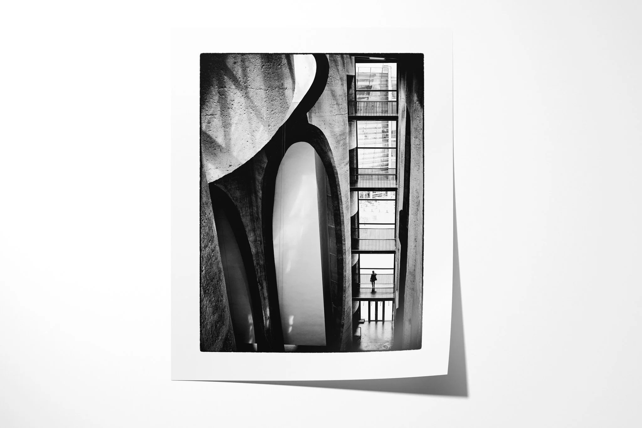 Unframed fine art paper print of Organ Pipes, showing monumental curved concrete forms beside stacked walkways, with a solitary figure visible in a high-contrast interior.