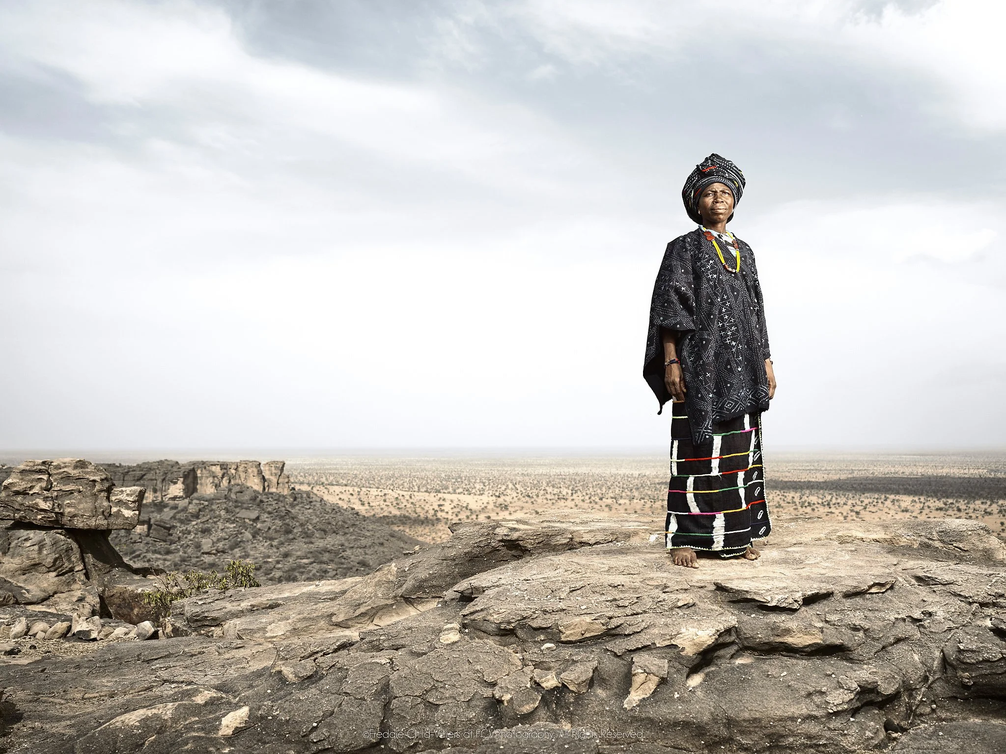Timbe standing on the edge of the Bandiagara Escarpment above the Sahel plain.