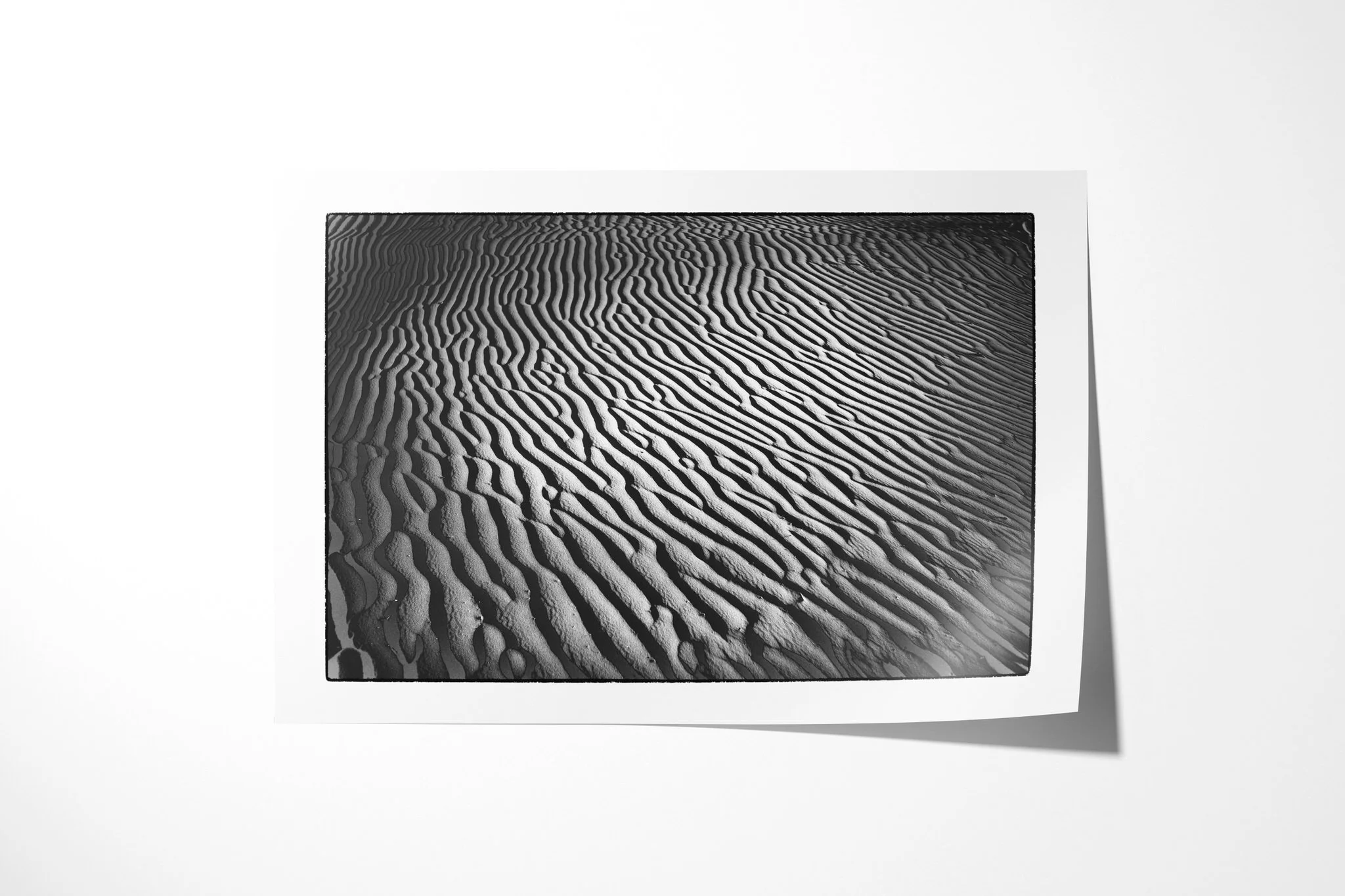 Fine art paper print of Khamsin I, showing closely spaced sand ripples sweeping diagonally through alternating bands of light and shadow.