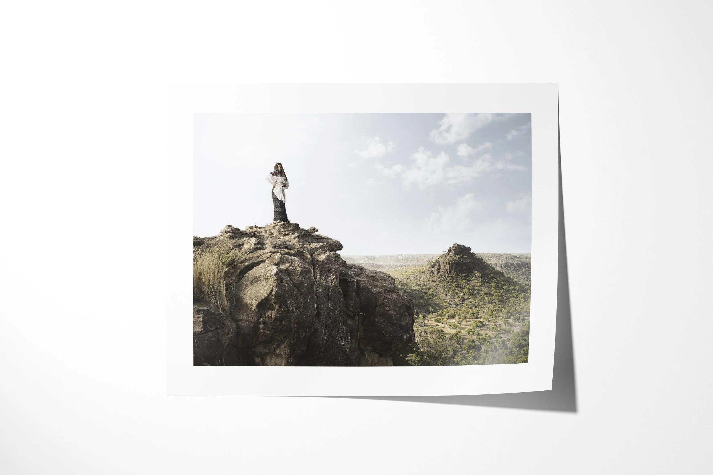 Fine art paper print of Fante, showing Fante standing on a high rocky ledge above a green valley and distant escarpment.