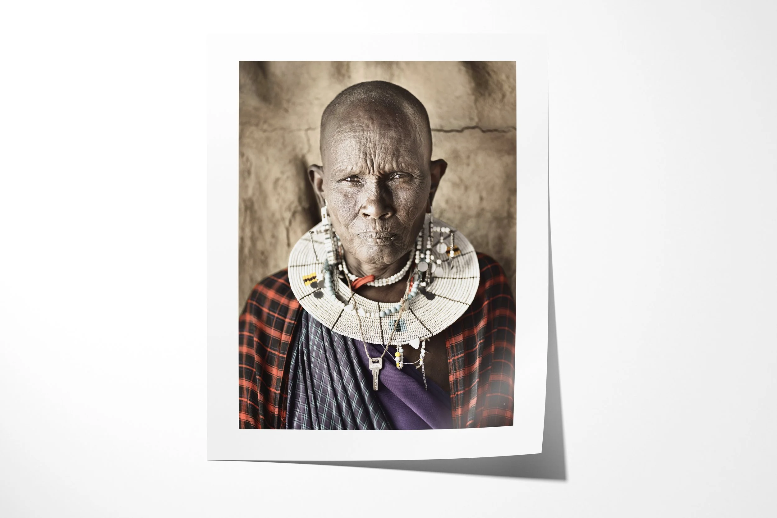 Fine art paper print of Naleku, showing a close portrait of a Maasai elder wearing a white bead collar and checked cloth.