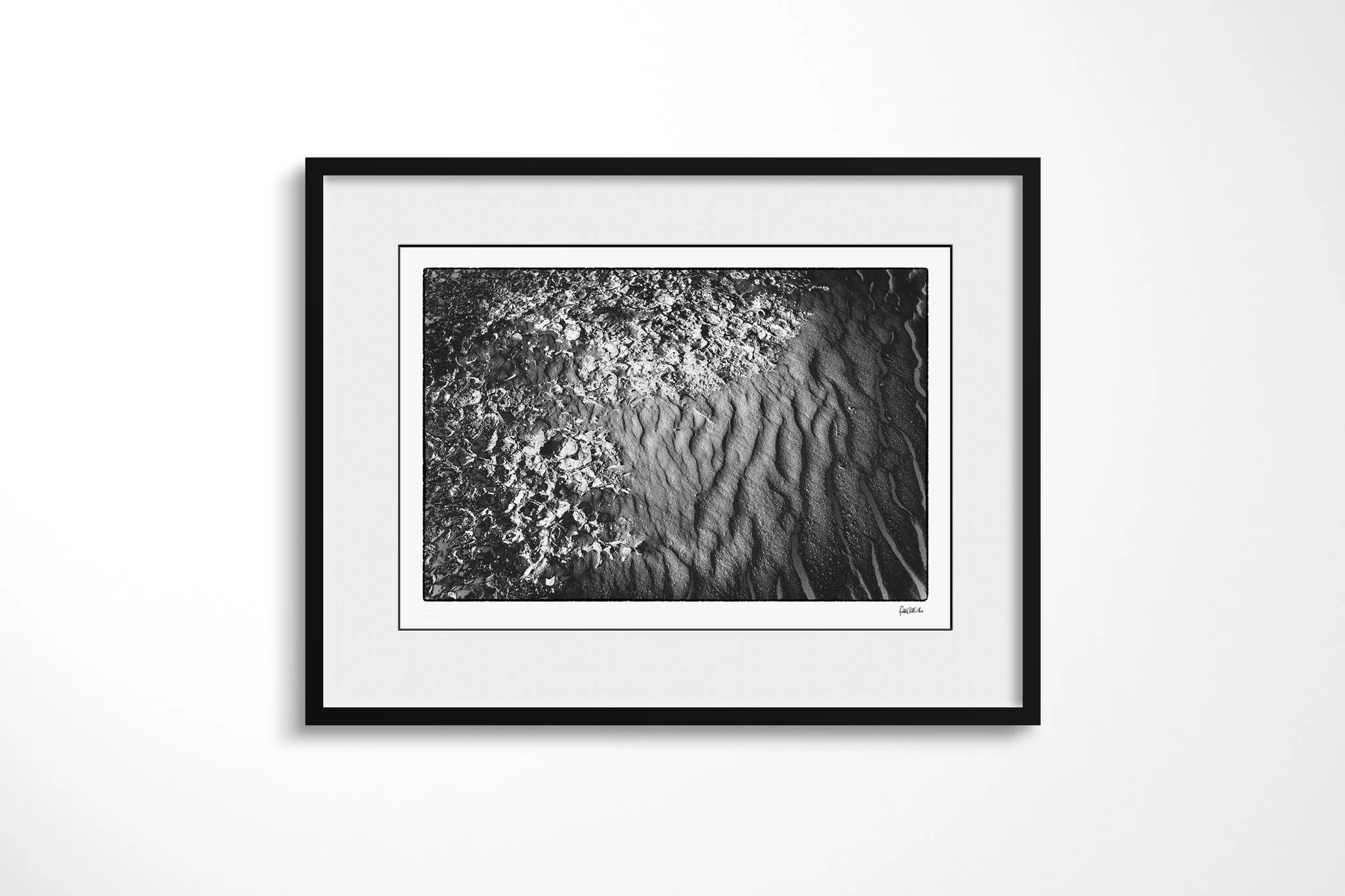 Black-framed presentation of Khamsin III with a wide white mount, featuring broken granular crust meeting smoother rippled sand along an irregular curved boundary.