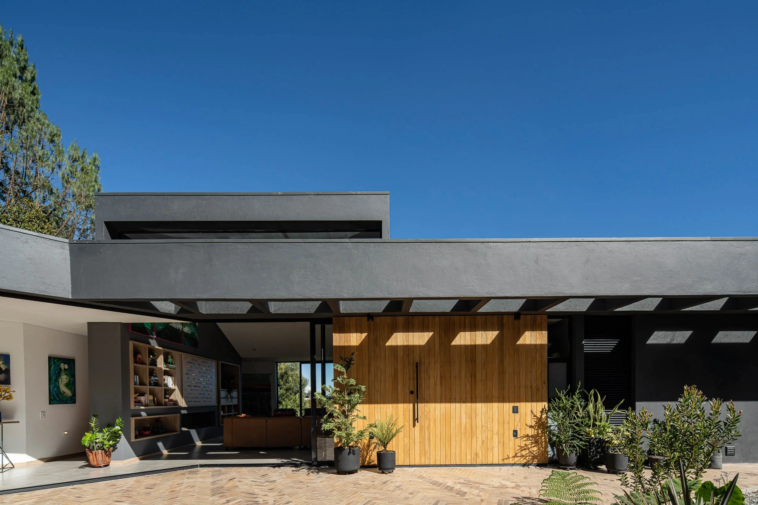 Casa contemporánea con puerta grande de madera ubicada a las afueras de Medellín. Casa JANA, diseñada por TOLEDO Estudio de Arquitectura