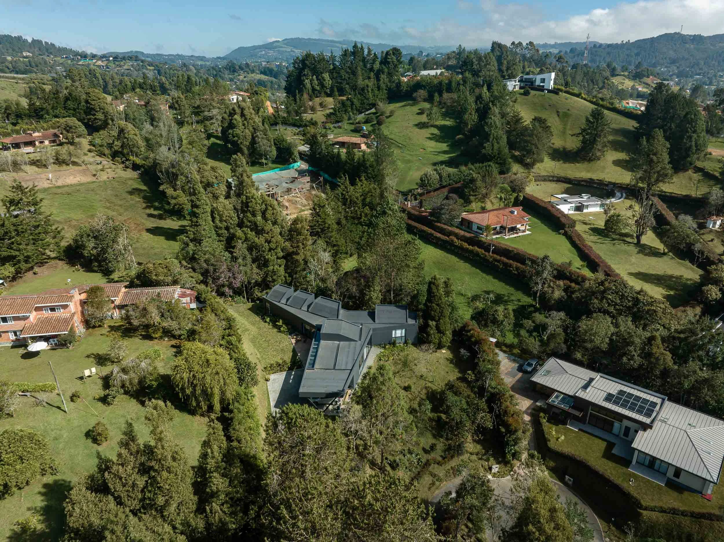 Vista aérea de Casa JANA en medio de una montaña, rodeada de bosque. Una casa de arquitectura contemporánea que destaca en su entorno. Diseño por TOLEDO Estudio de Arquitectura.