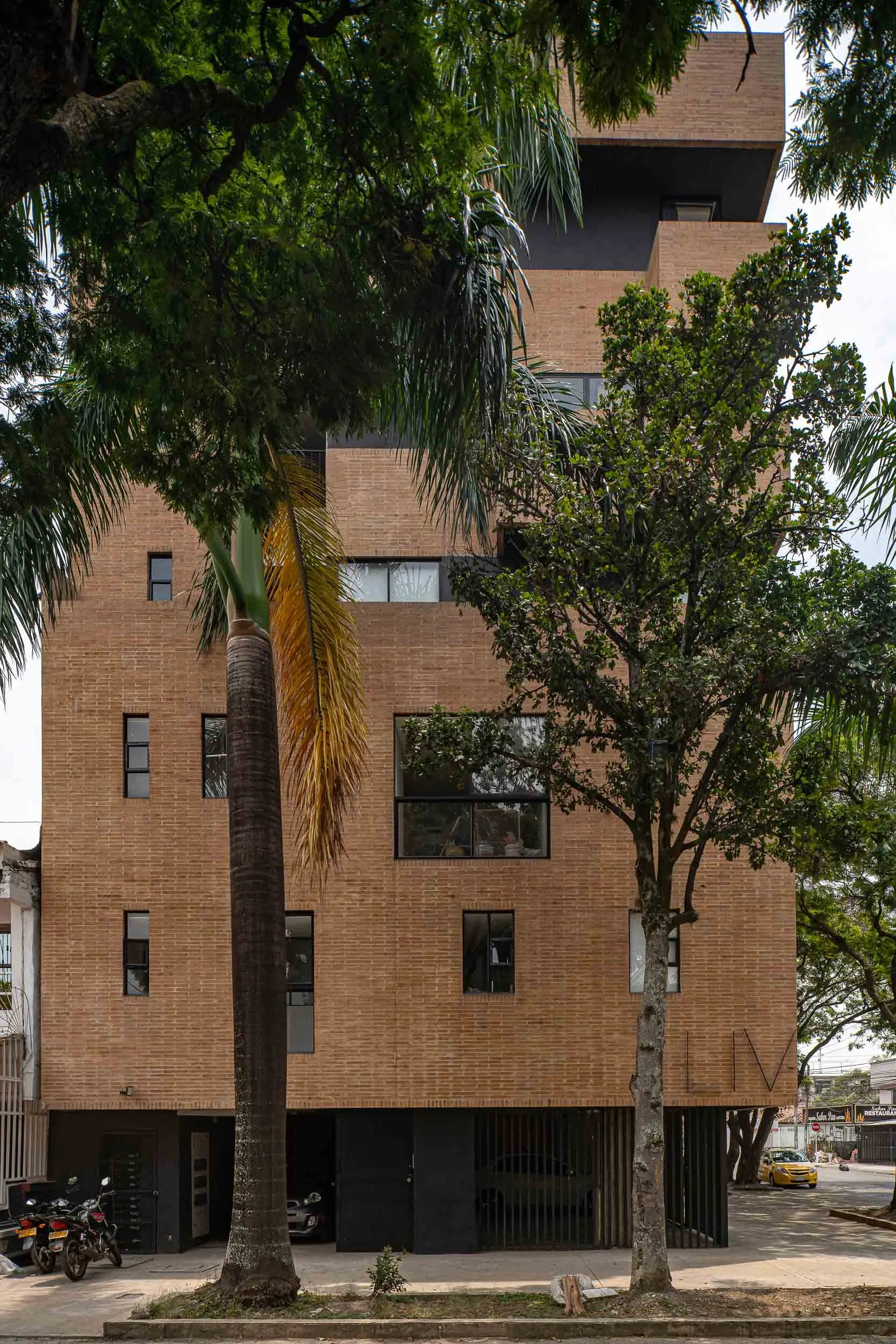 Liv37 detrás de árboles. Arquitectura residencial moderna en Cali, Colombia por TOLEDO Estudio de Arquitectura.