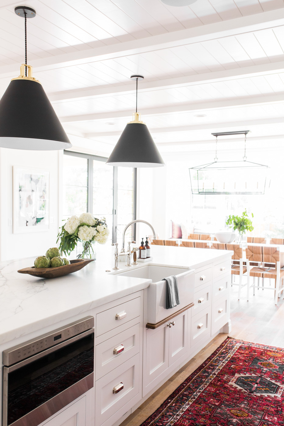 Modern+farmhouse+meets+The+Hamptons+in+Studio+McGee's+latest+remodel+--+vintage+kitchen+rug,+black+cone+pendants,+marble+counters,+farmhouse+sink,+bridge+faucet.jpg