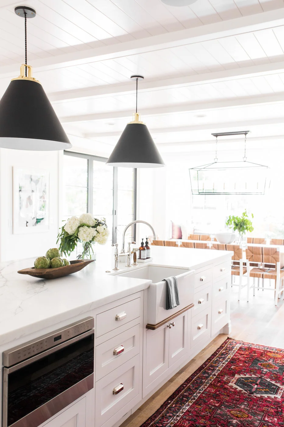 Modern+farmhouse+meets+The+Hamptons+in+Studio+McGee's+latest+remodel+--+vintage+kitchen+rug,+black+cone+pendants,+marble+counters,+farmhouse+sink,+bridge+faucet.jpg