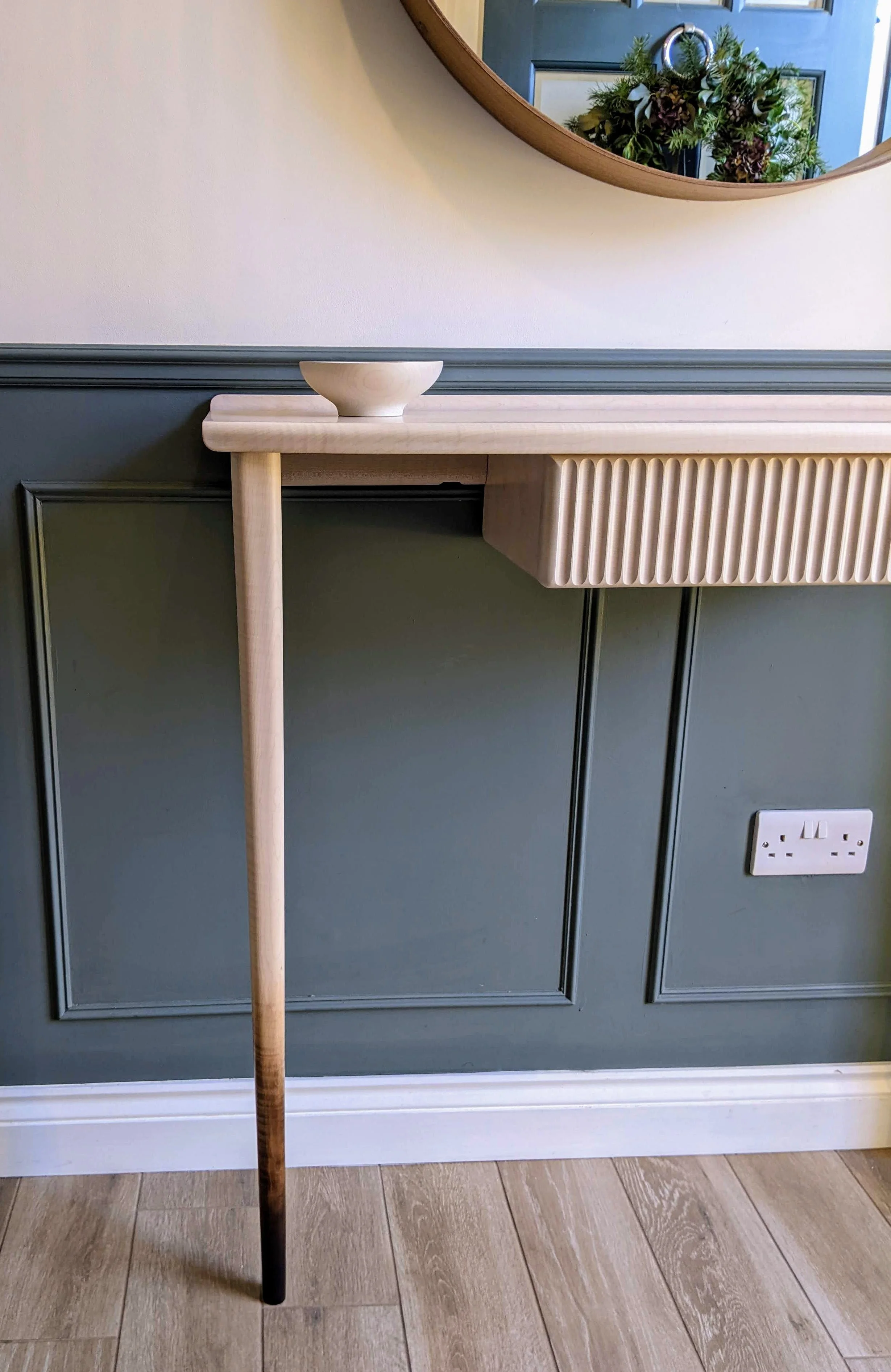 A sculptural console table with feather-like top grain in bleached ash ...