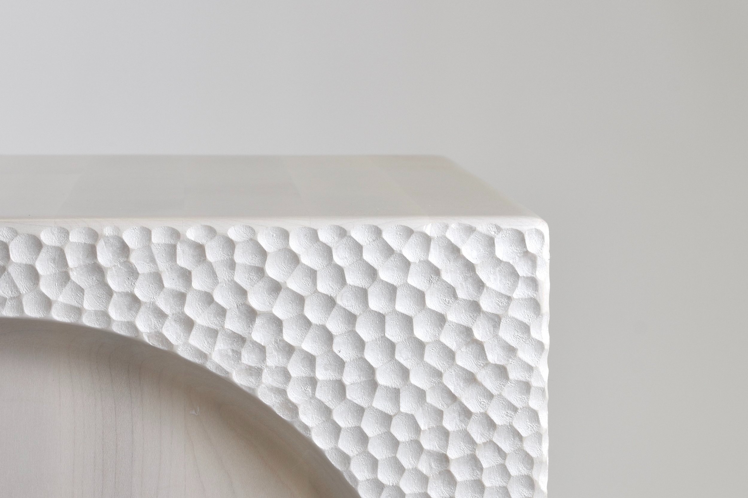 Textured white wood cube with circular relief
