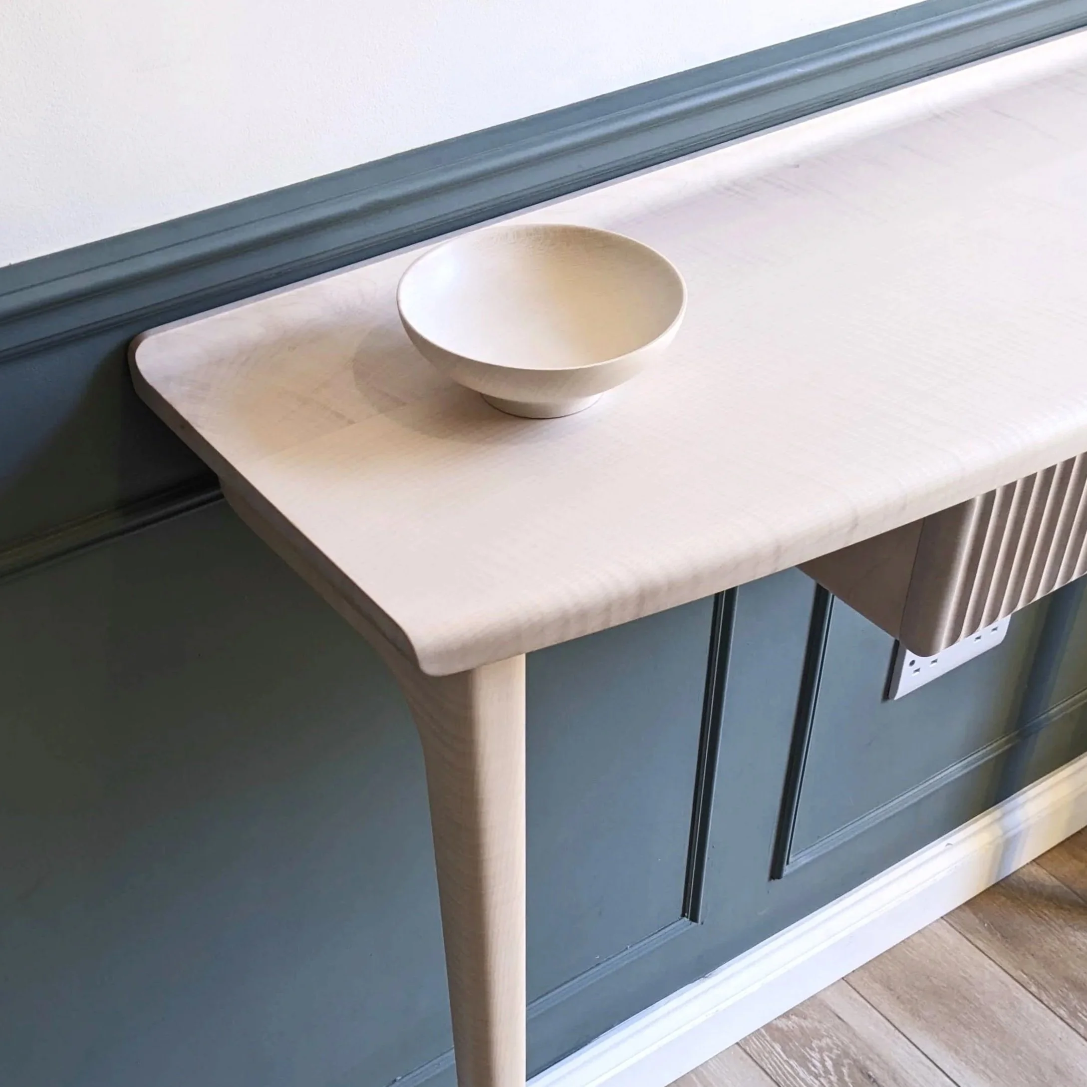 A sculptural console table with feather-like top grain in bleached ash ...