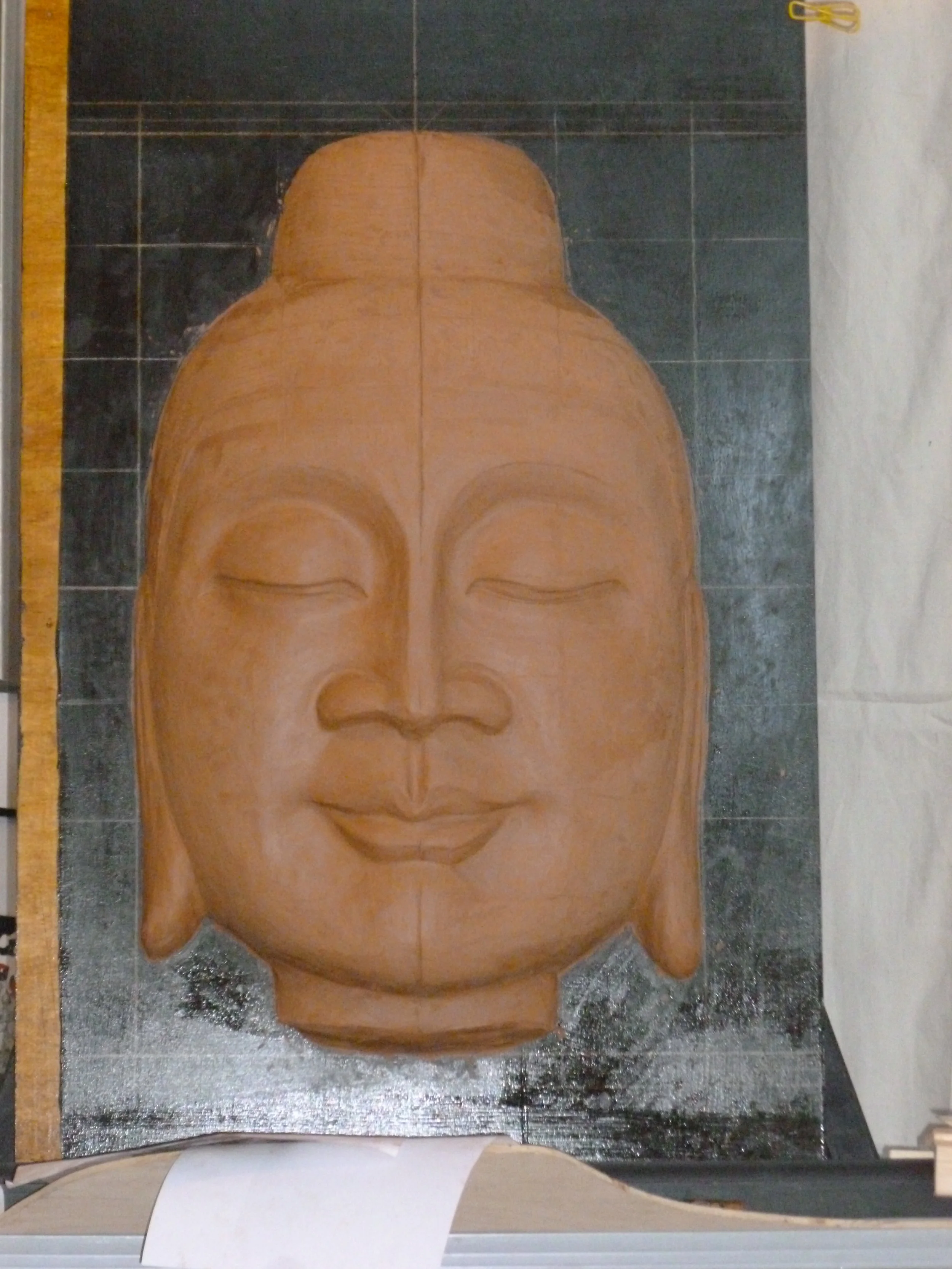 Sculpting the clay model for the Fountain Buddha. The grid is used for assessing symmetry.