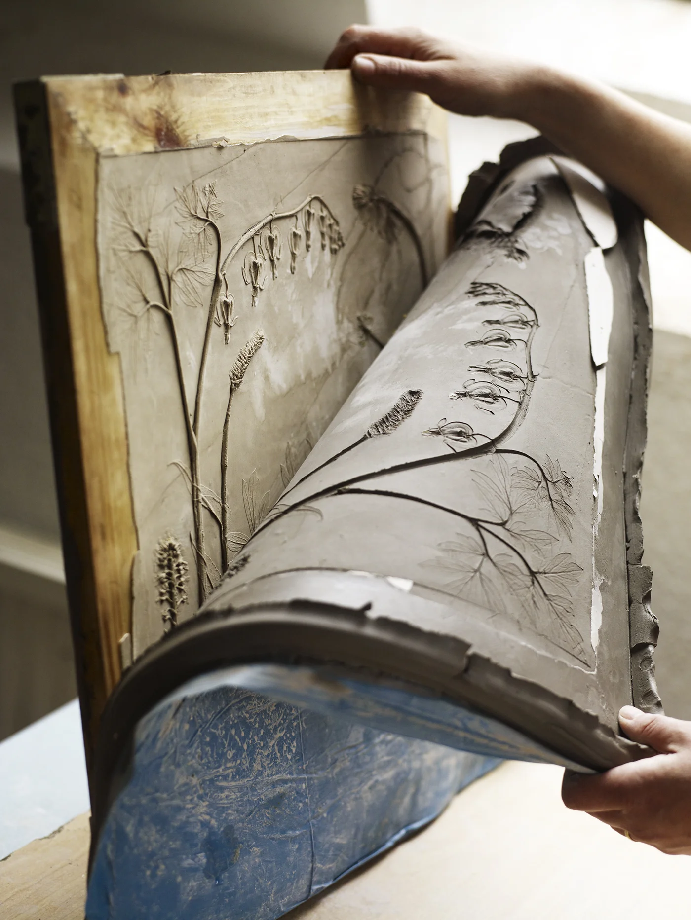 Peeling the clay waste mold off the hardened plaster. Photo by Andrew Montgomery, courtesy of the artist.