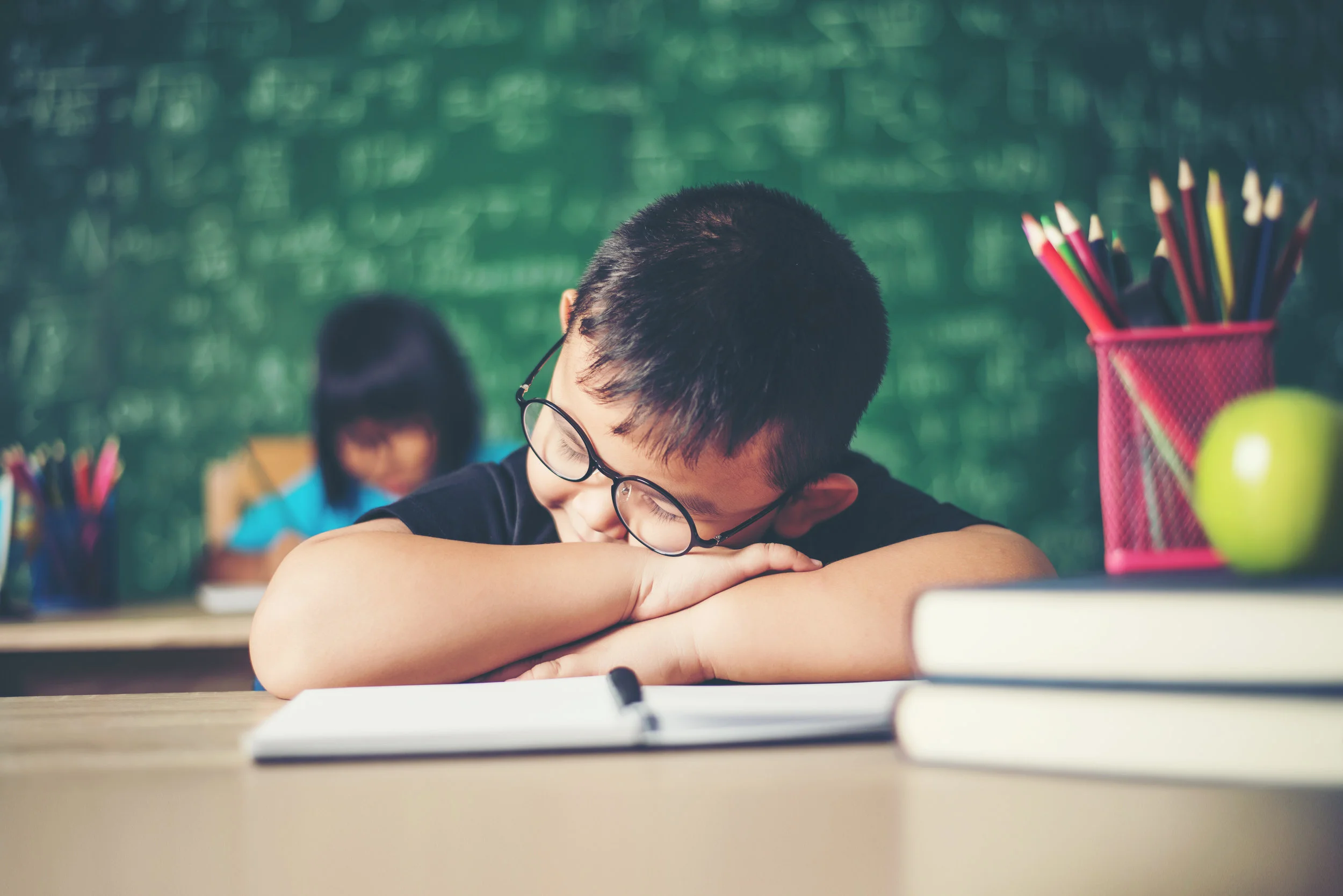 Boy_sleeping_on_the_books_in_the_classroom..jpeg